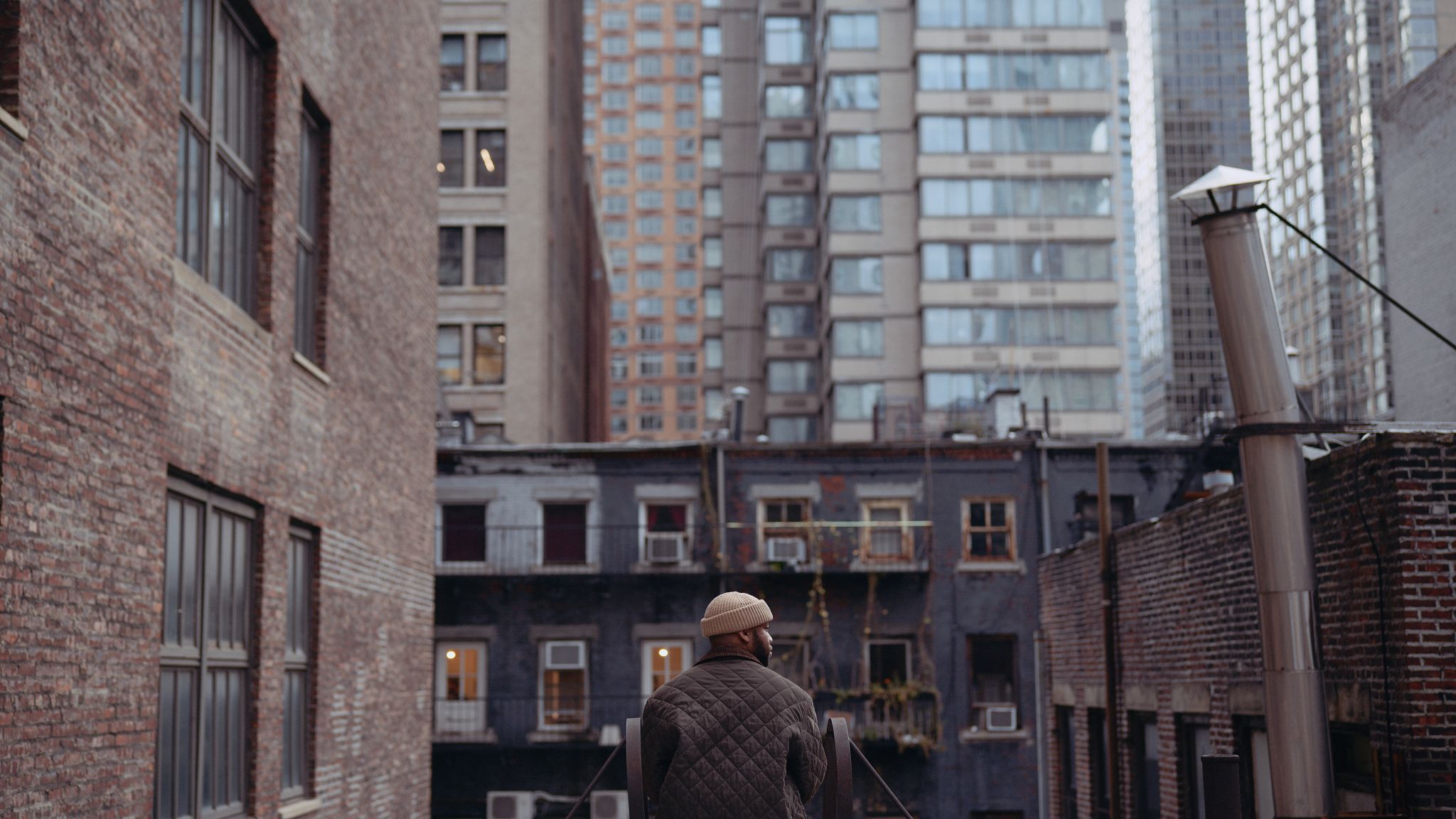 C&I Films From New York, I Love You Still of view from behind of man wearing a beige knit cap looking out over the city