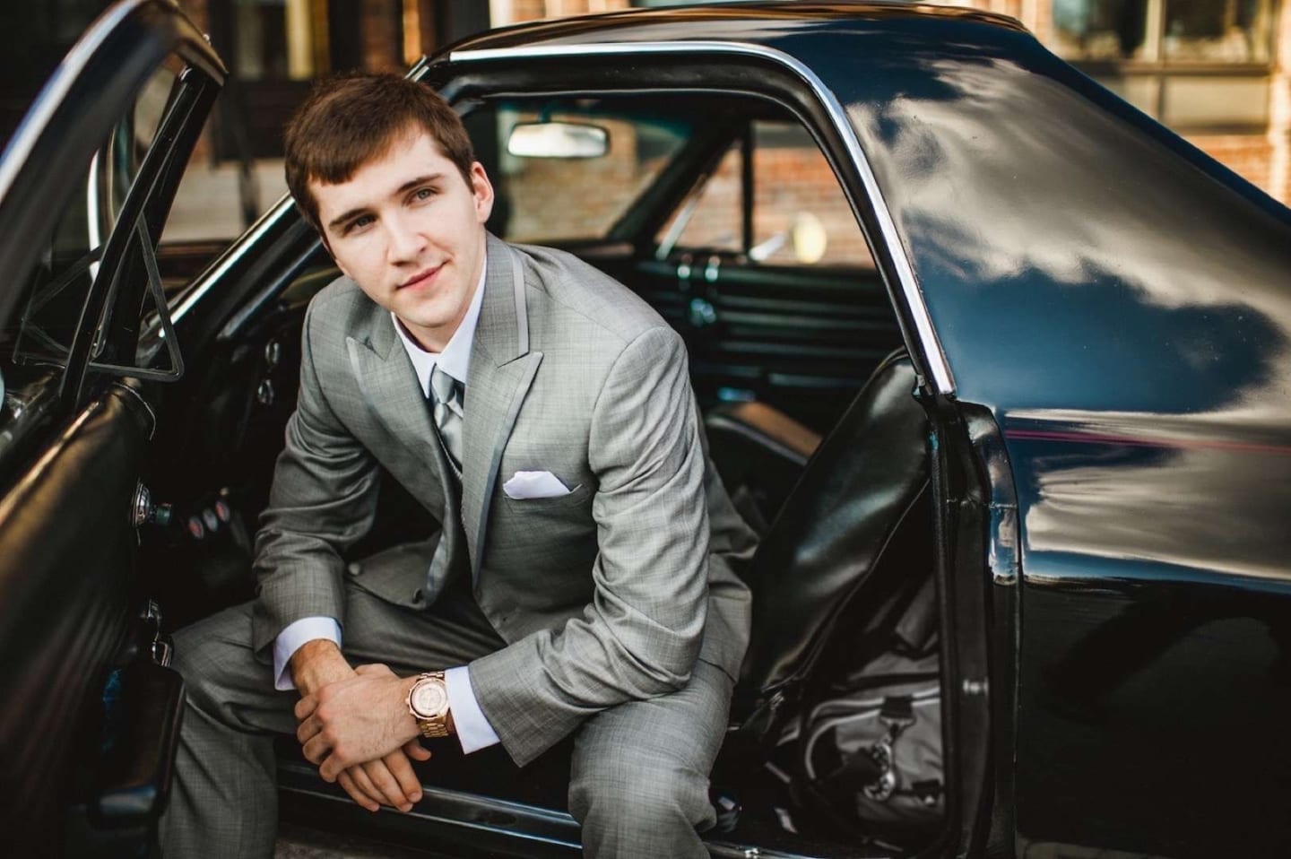 Mens Wearhouse Sprin Lookbook Young man in a gray suit looking out from the car posing for camera