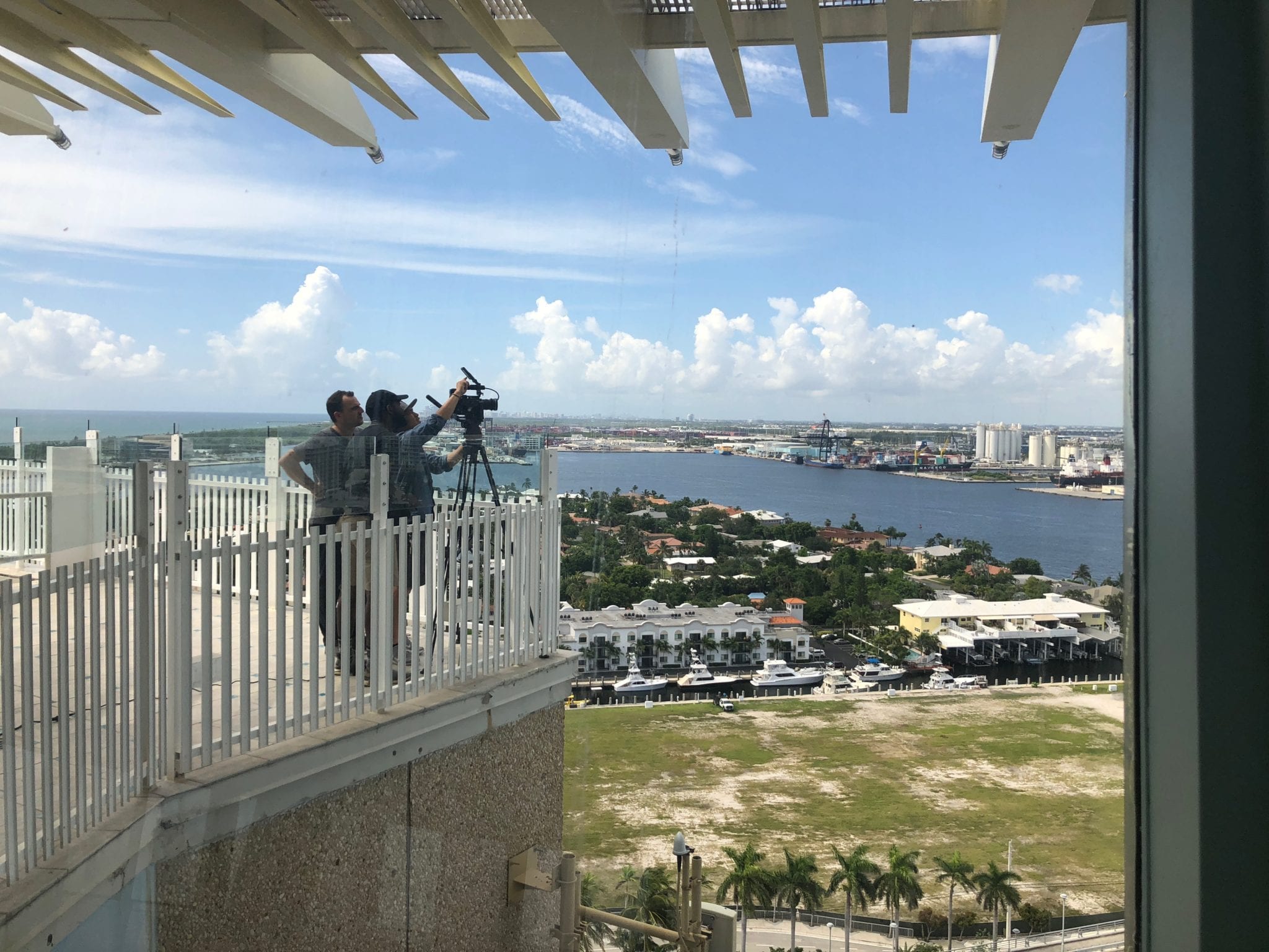 Go Pro Video cameraman setting up equipment on a platform overlooking the city and yacht club