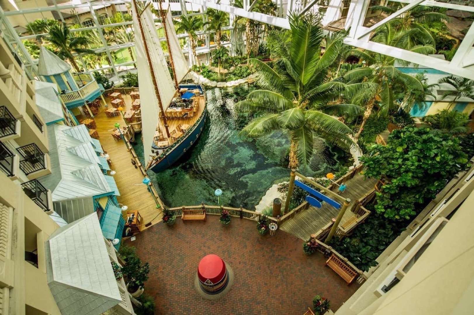 Gaylord Palms Resort and Convention Center Overhead view of Interior showing a marine themed area with a small ship, walkways, marker, palm trees and trees.