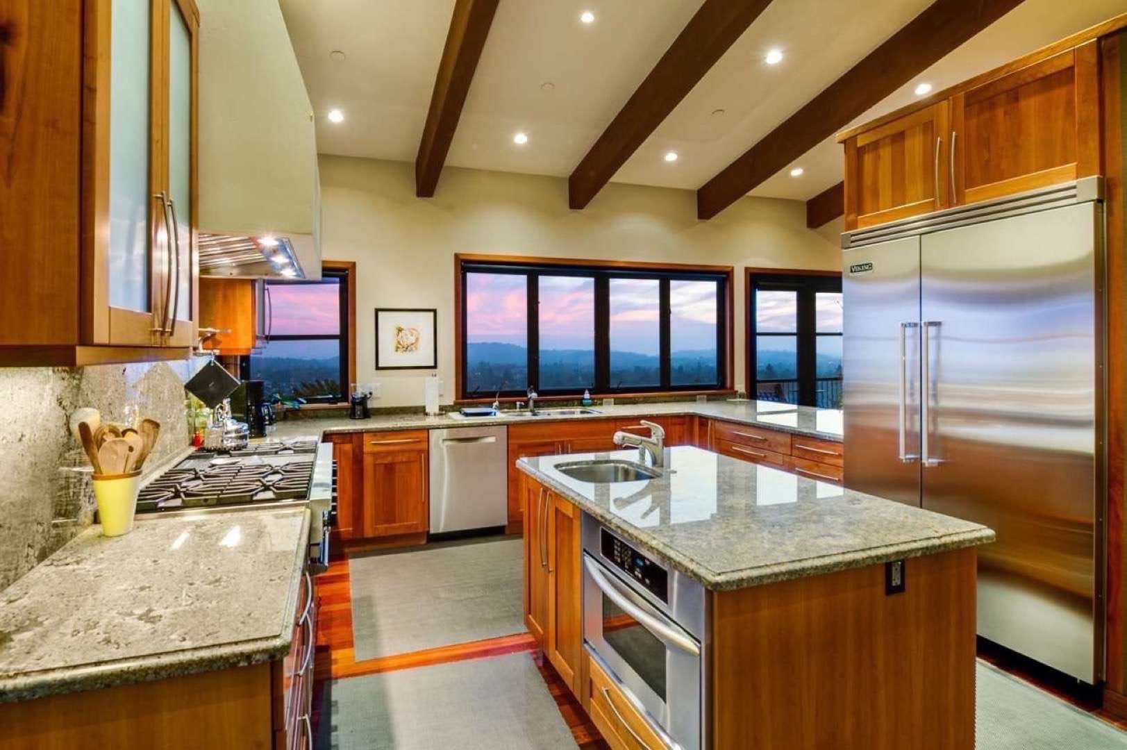 Truly Great Homes View of kitchen area of a house with granite countertops overlooking a valley. There is a large stainless steel refrigerator/freezer.