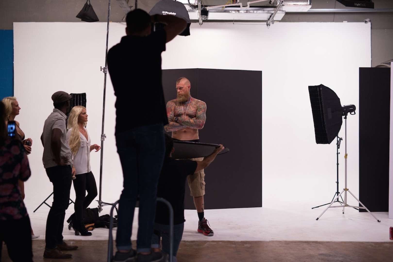 Tattooed man with mohawk posing for camera man and crew