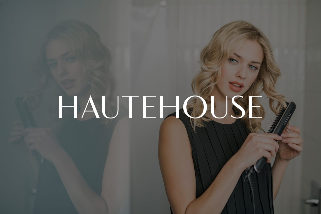 HauteHouse Brands Theorie and Sedu Woman with long blond hair posing for camera using a curling iron