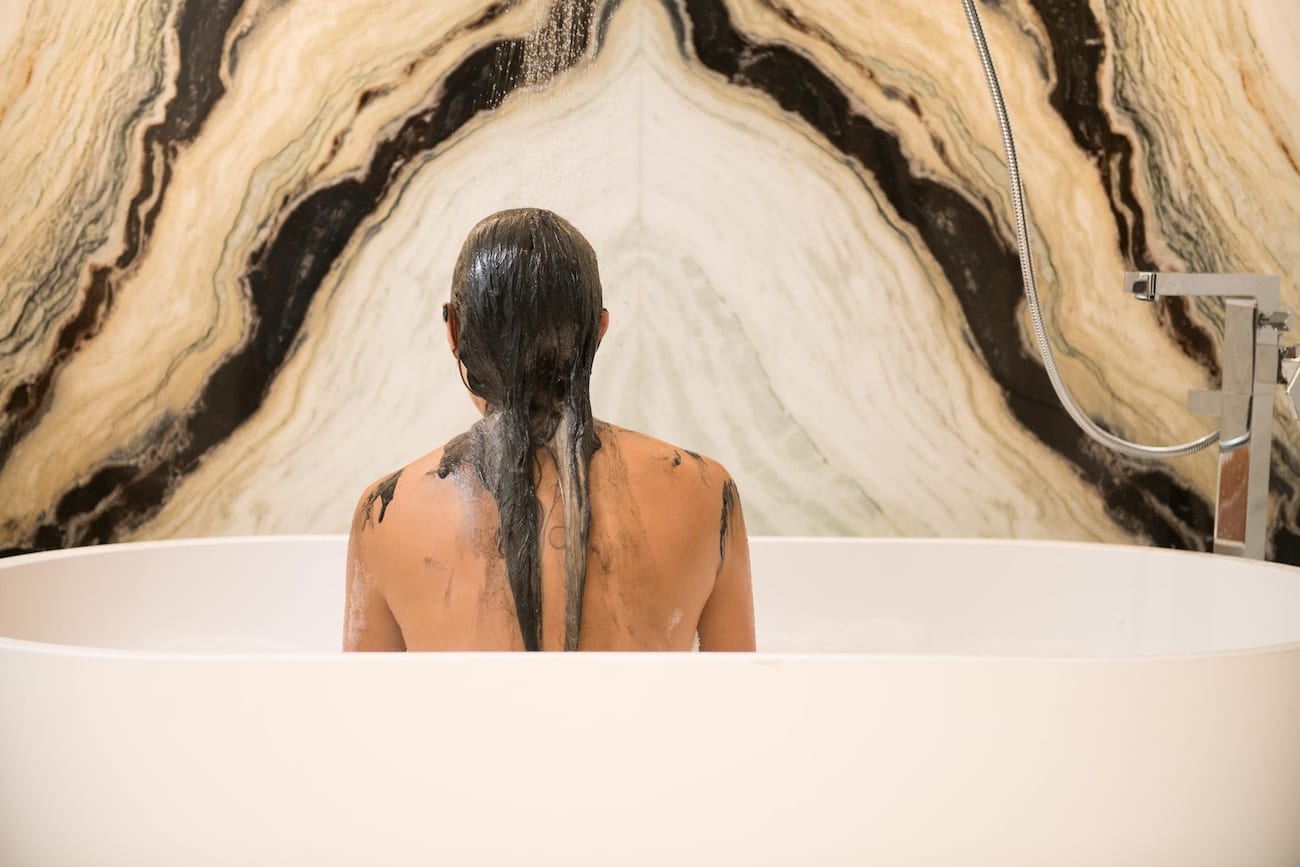 Woman in a bathtub that just applied hair dye