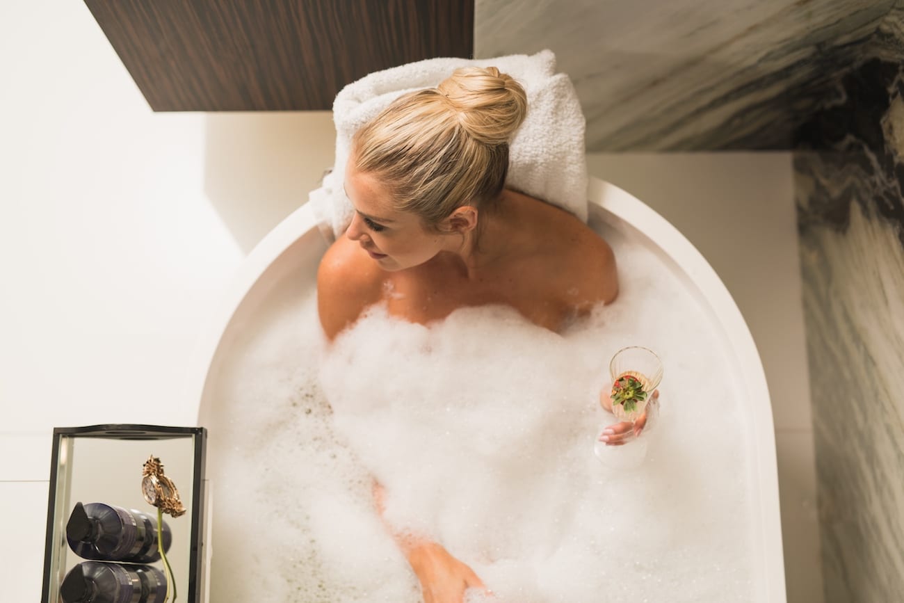 Woman in a bubble bath with a glass of champagne