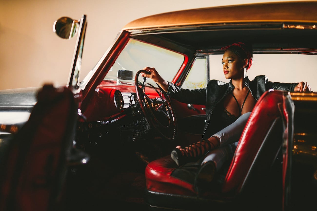 Fort Lauderdale Studio Rental Woman posing for camera from inside a vintage car with red seats