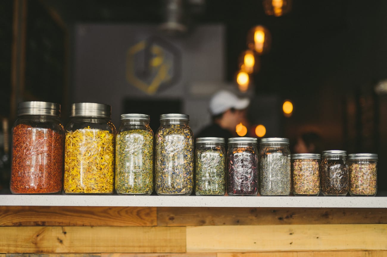 Group of herbs in mason jars on a counter