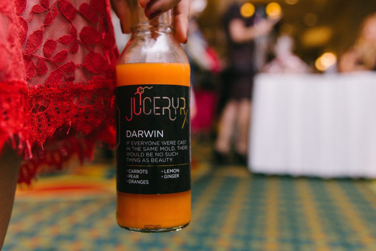 Darwin flavored juice being displayed next to woman in red dress