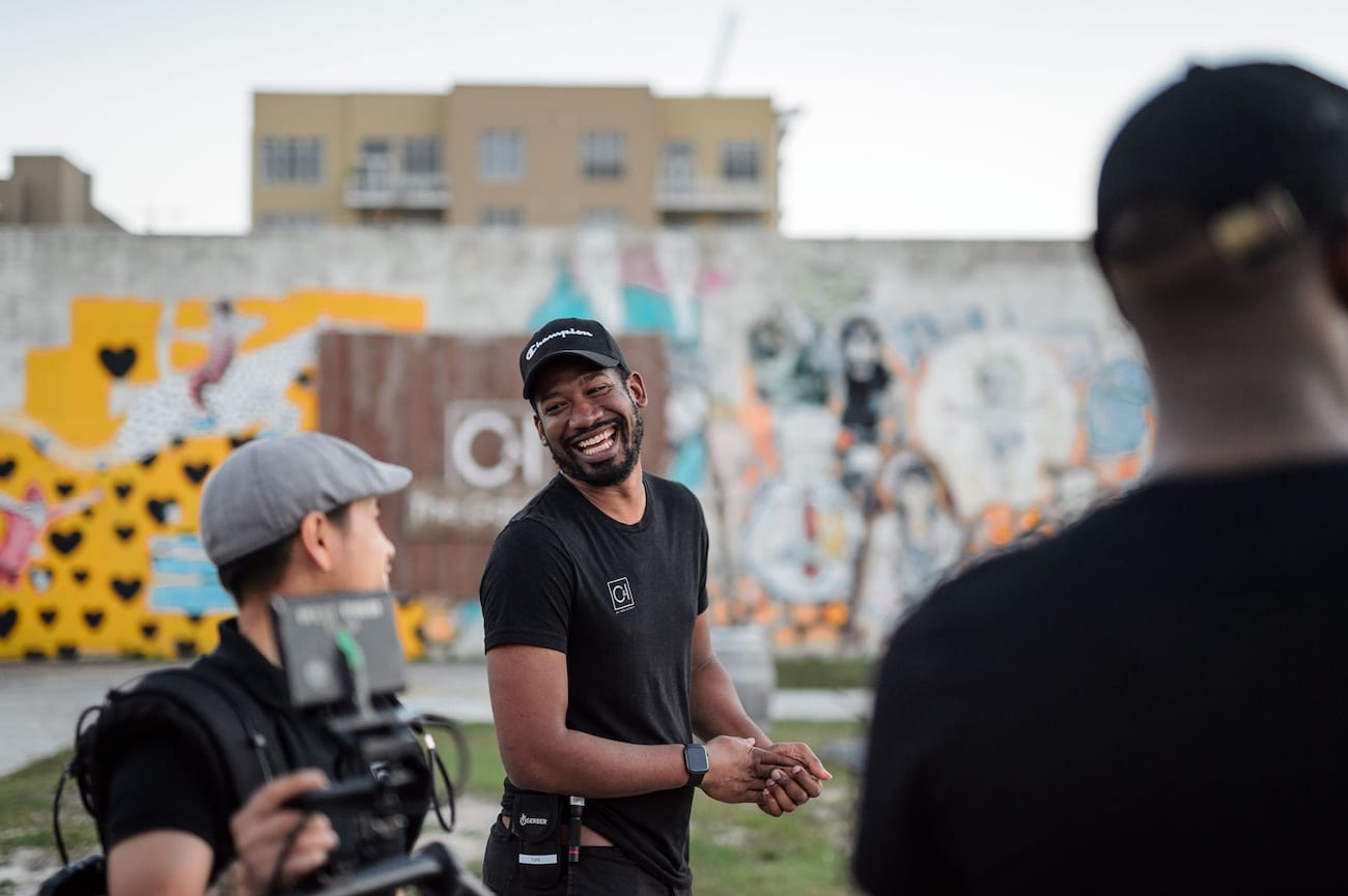 OneUnited BTS 27 Advertising Agency in Fort Lauderdale CI Studios staff member smiles at video cameraman