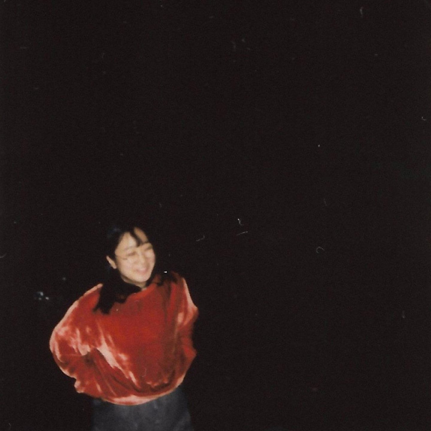 Yaeji Artist Profile Blurry image of a woman wearing a red velvety-like sweater