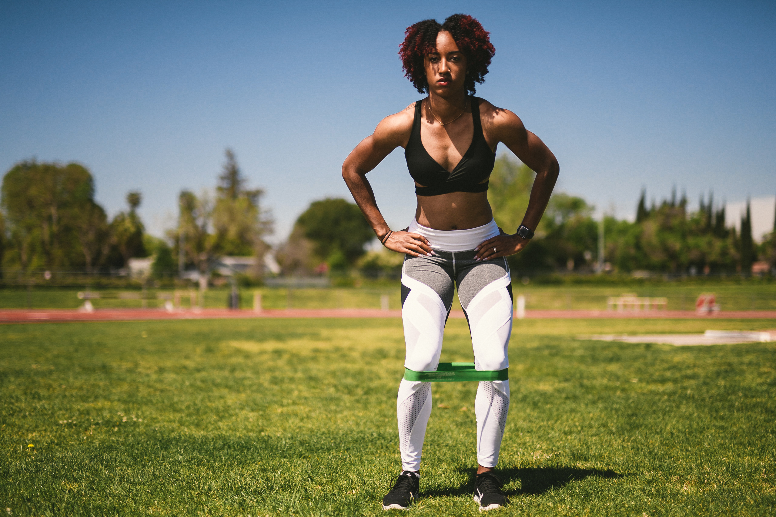 Professional Photography Services to elevate your brand C&I Studios Creative Marketing Kinetix 365 Woman posing for camera on a track field in track outfit using rubber band for stretching