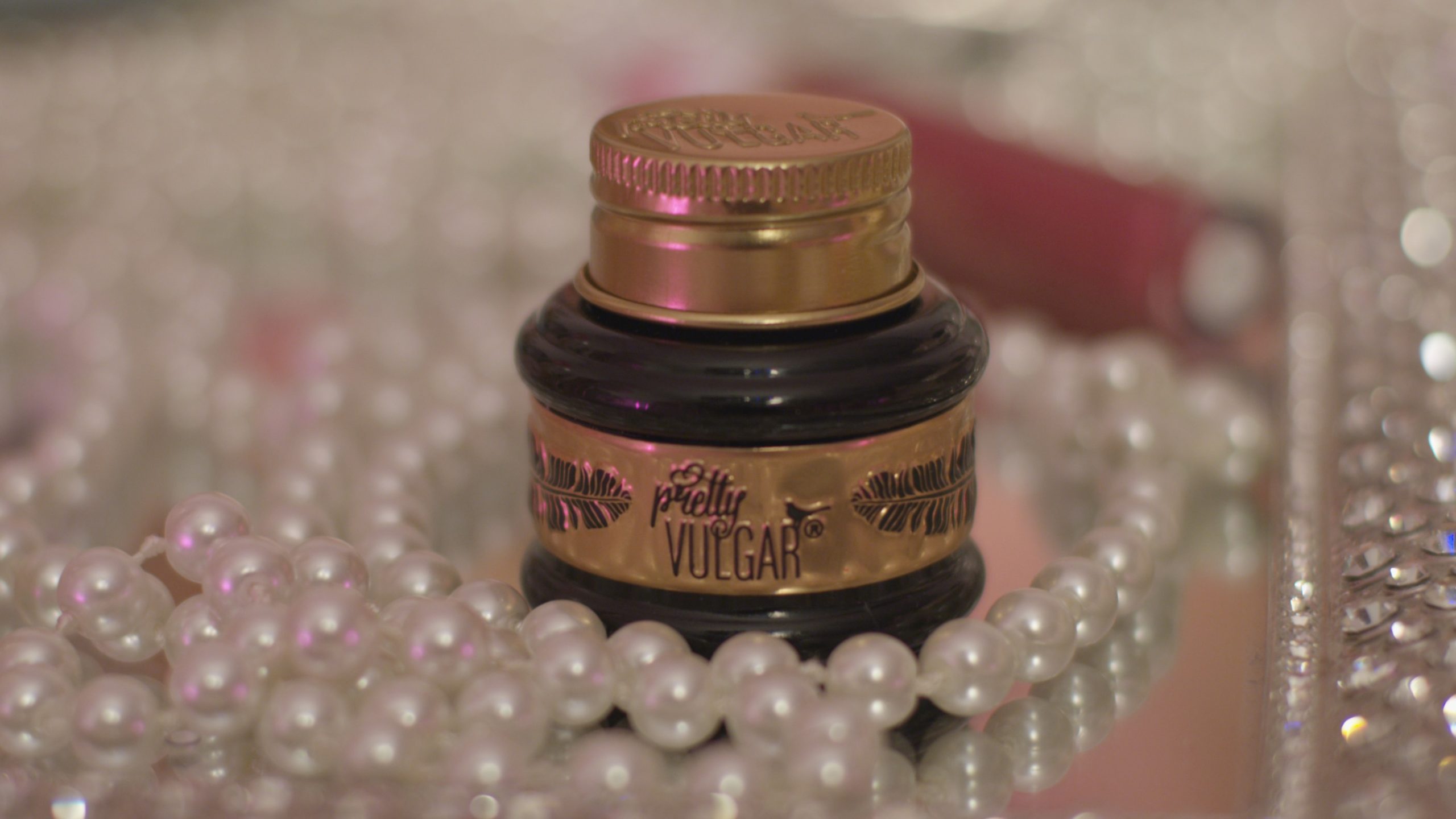 Close up of Pretty Vulgar makeup jug surrounded by pearls.