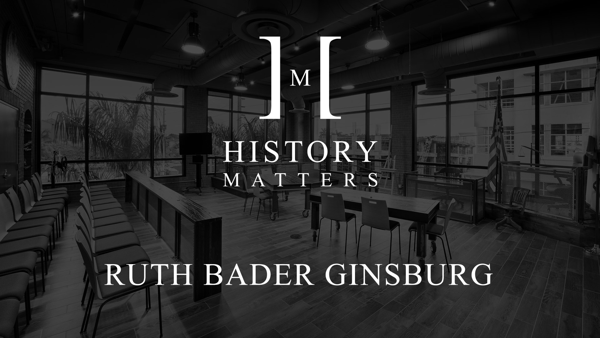 IU C&I Studios Page White HM Ruth Bader Ginsburg logo with dimmed black and white background of a classroom with chairs, tables and an American Flag logo with background