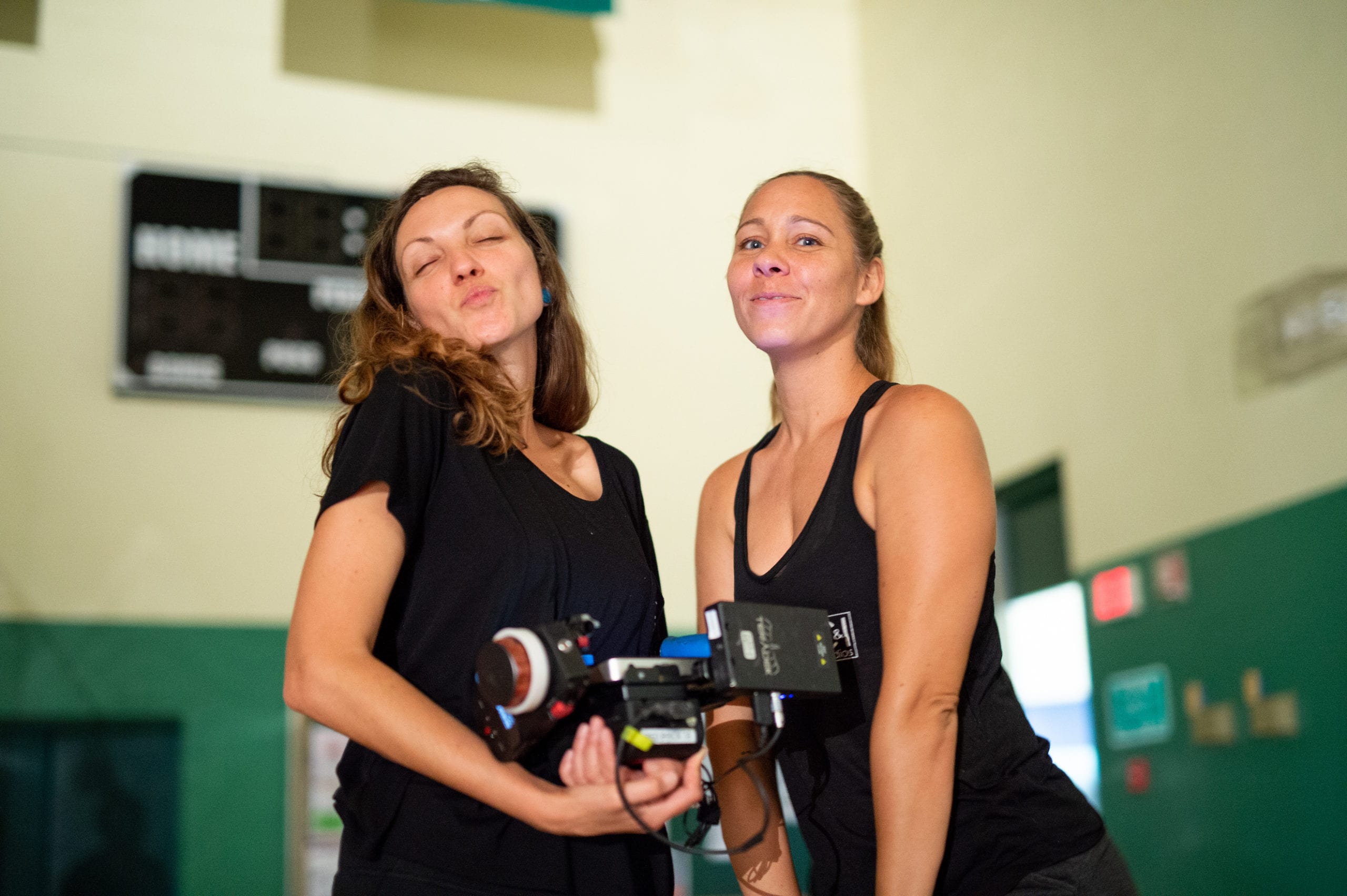 Vloggers creating their first video Female holding a video camera and another woman both posing for the camera