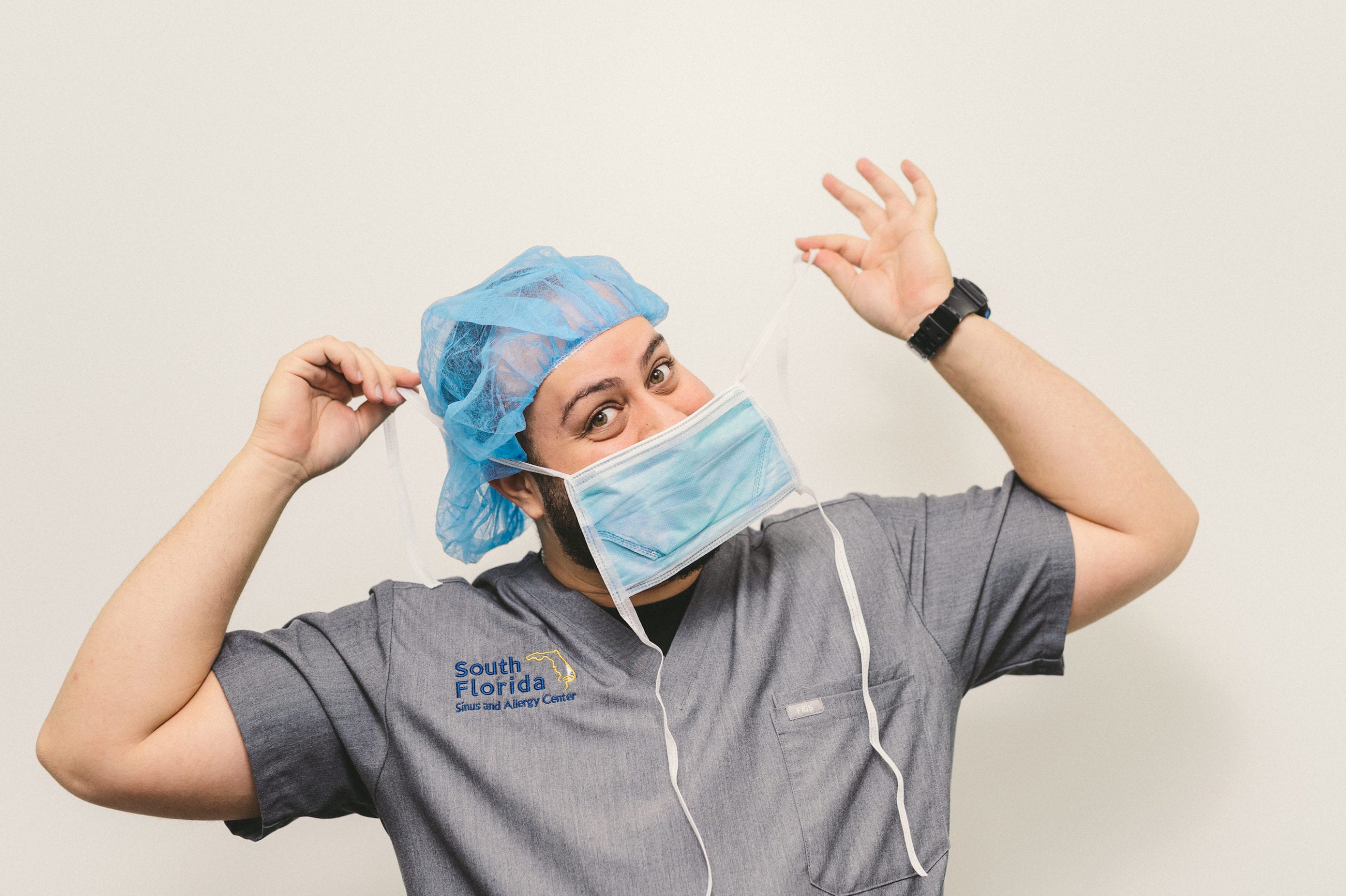 South Florida Sinus and Allergy Center Male doctor posing with hairnet and mask for the camera
