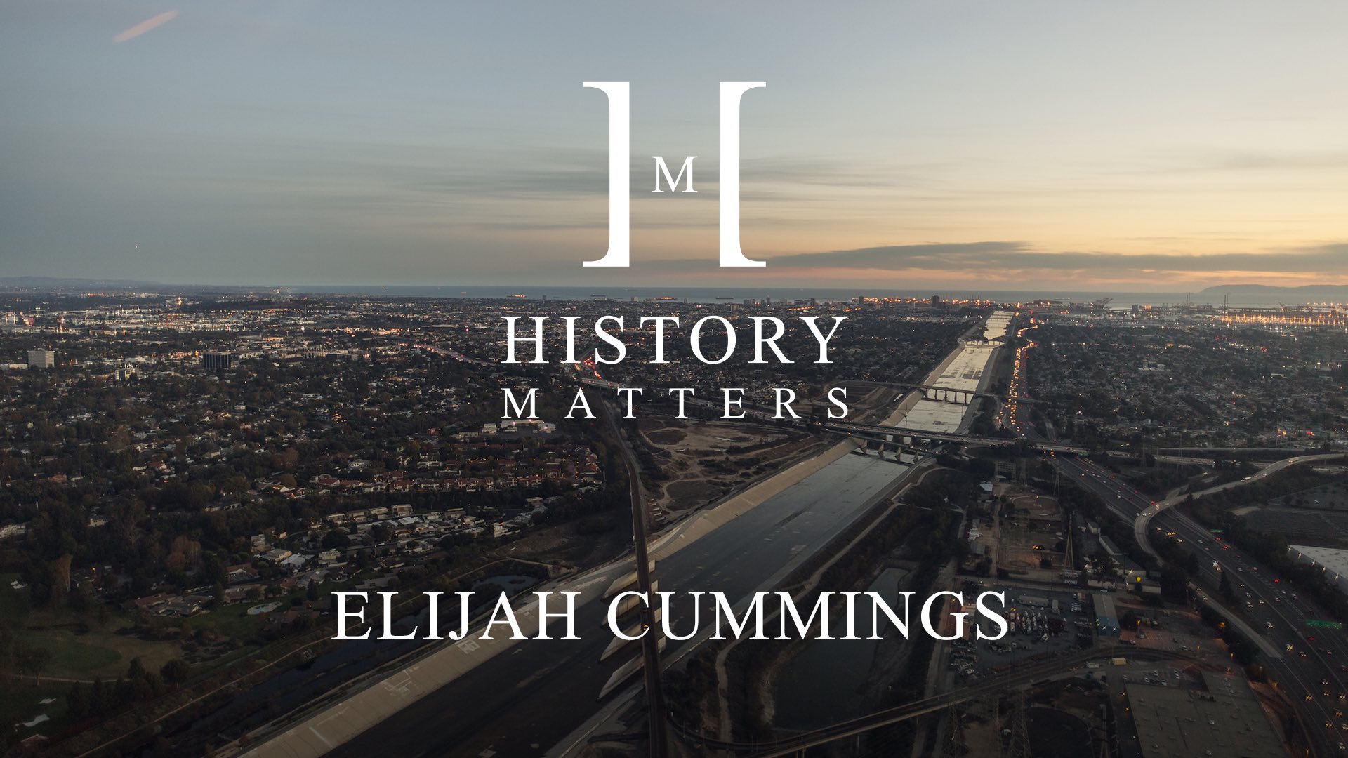 IU C&I Studios Page White HM Elijah Cummings logo with background aerial view of city with bridges crossing a waterway