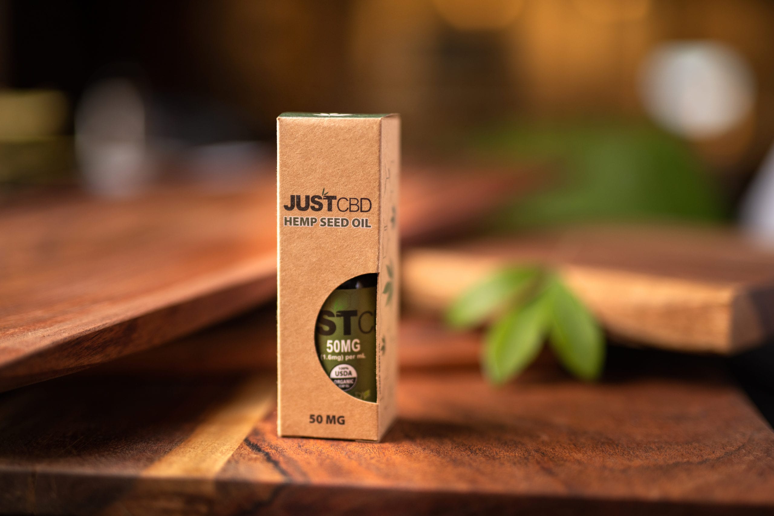 JustCBD Hemp Seed Oil container on display on a wooden table