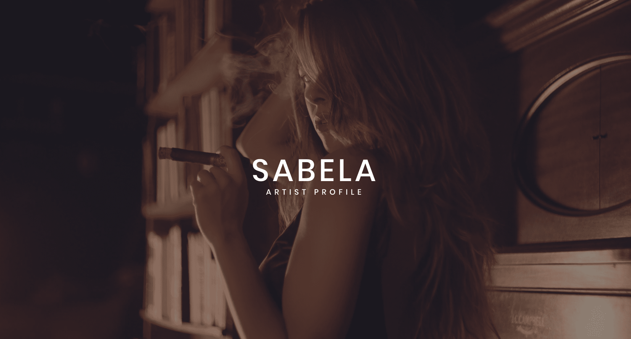 IU C&I Studios Portfolio and Page Sabela Artist Profile with Sabela with long hair holding a cigar posing for the camera