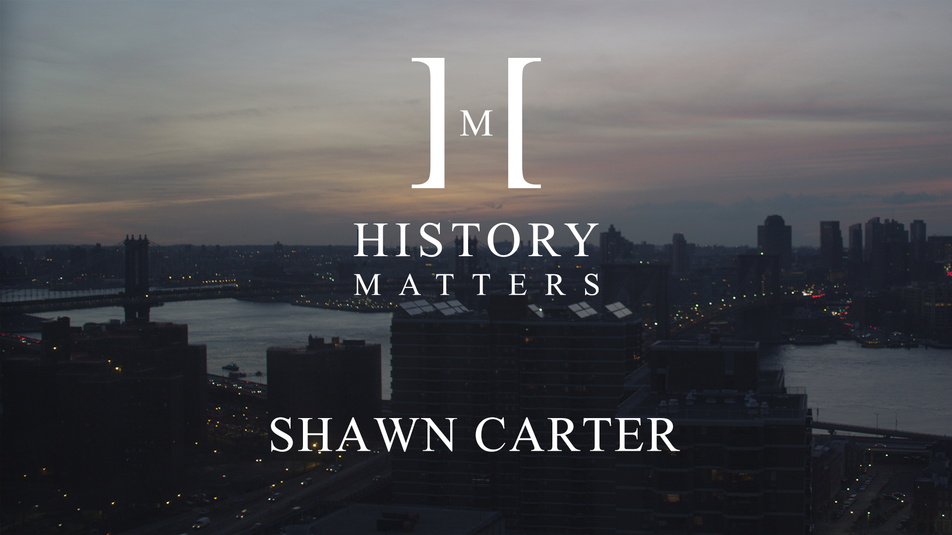 IU C&I Studios Page White HM Shawn Carter logo with background of city at dusk with bridges