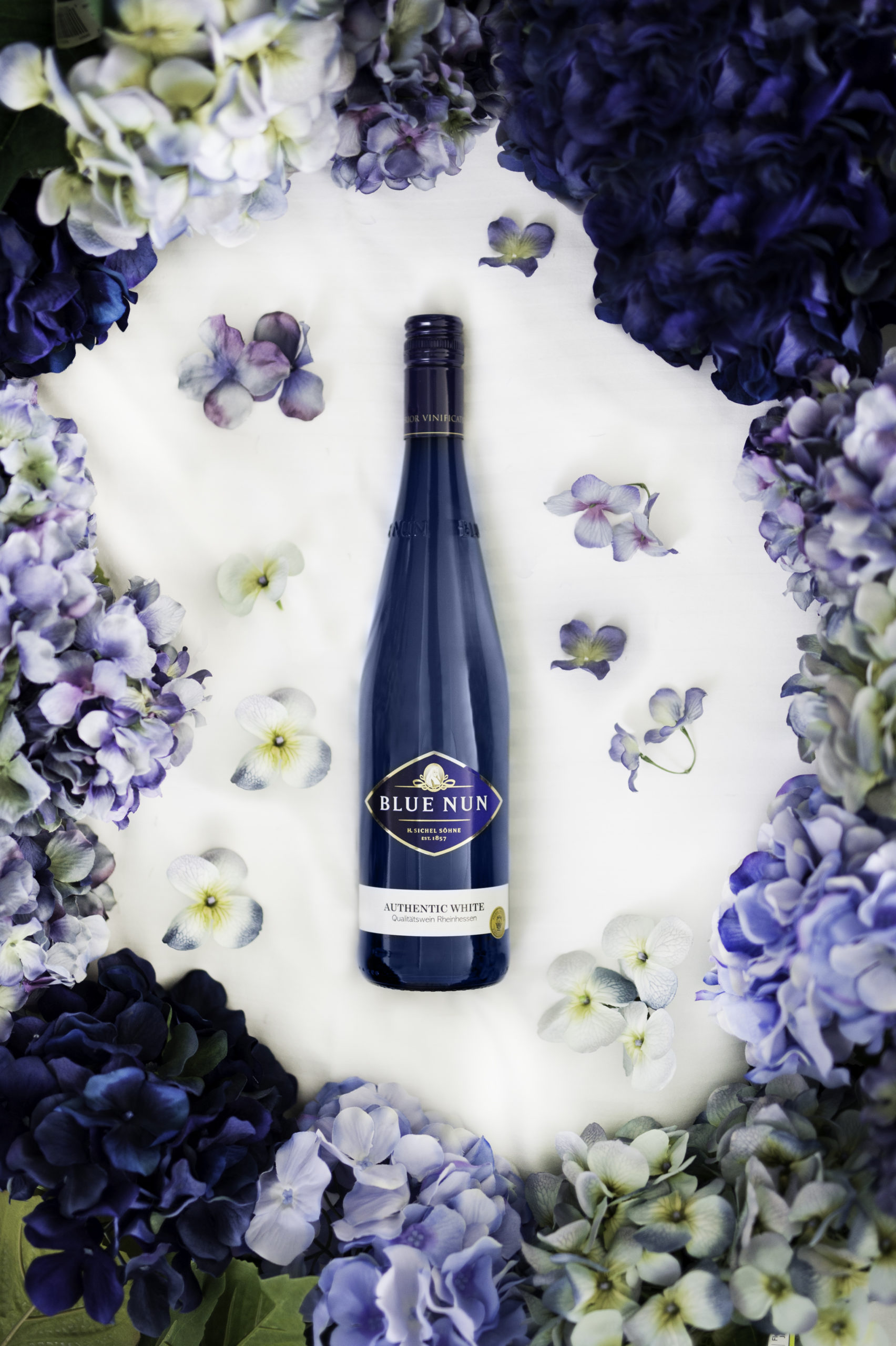Purple wine bottle surrounded by flowers