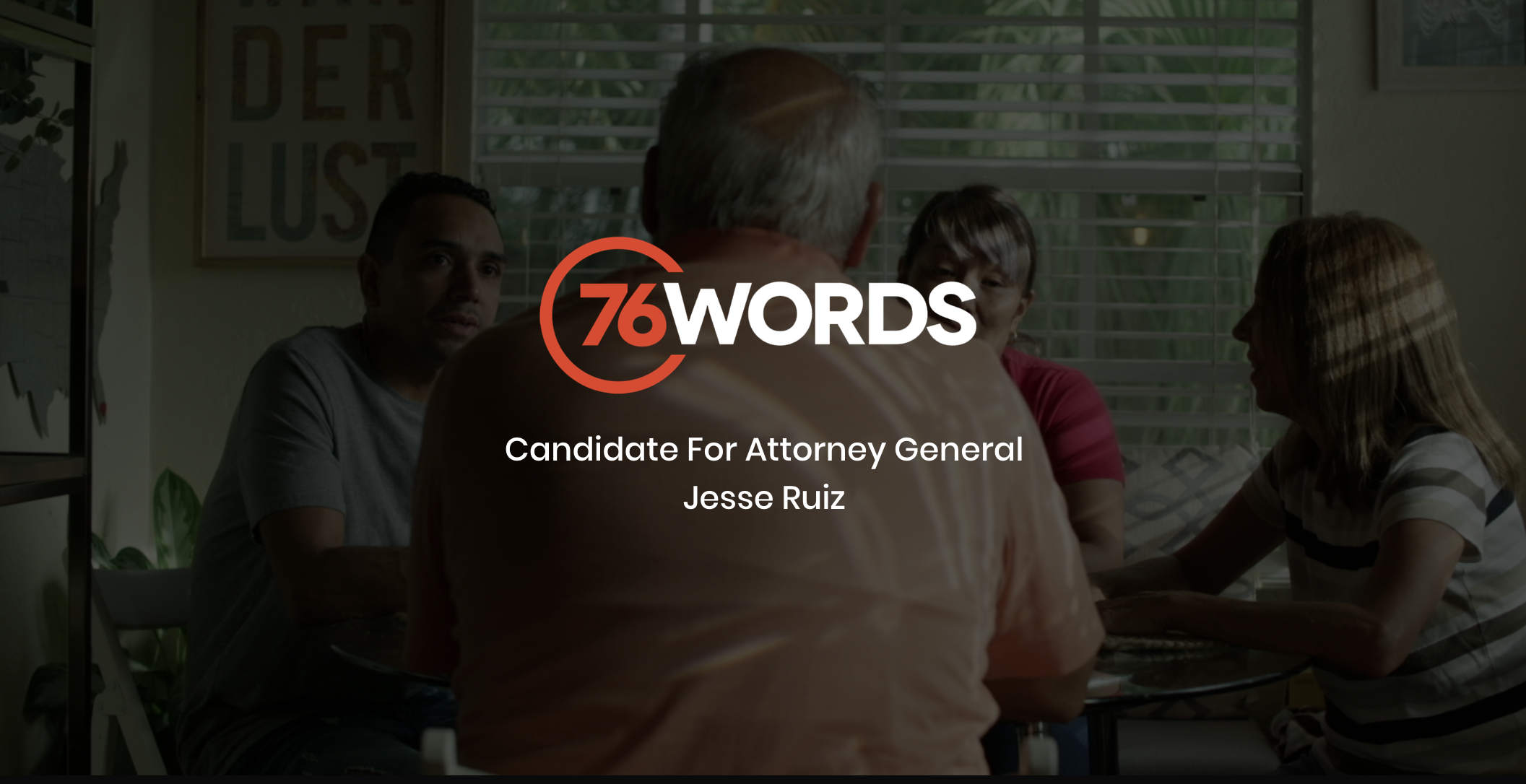 White and orange 76 Words Candidate For Attorney General Jesse Ruiz logo with dimmed background showing a group of two men and two women sitting around a table in a small room talking