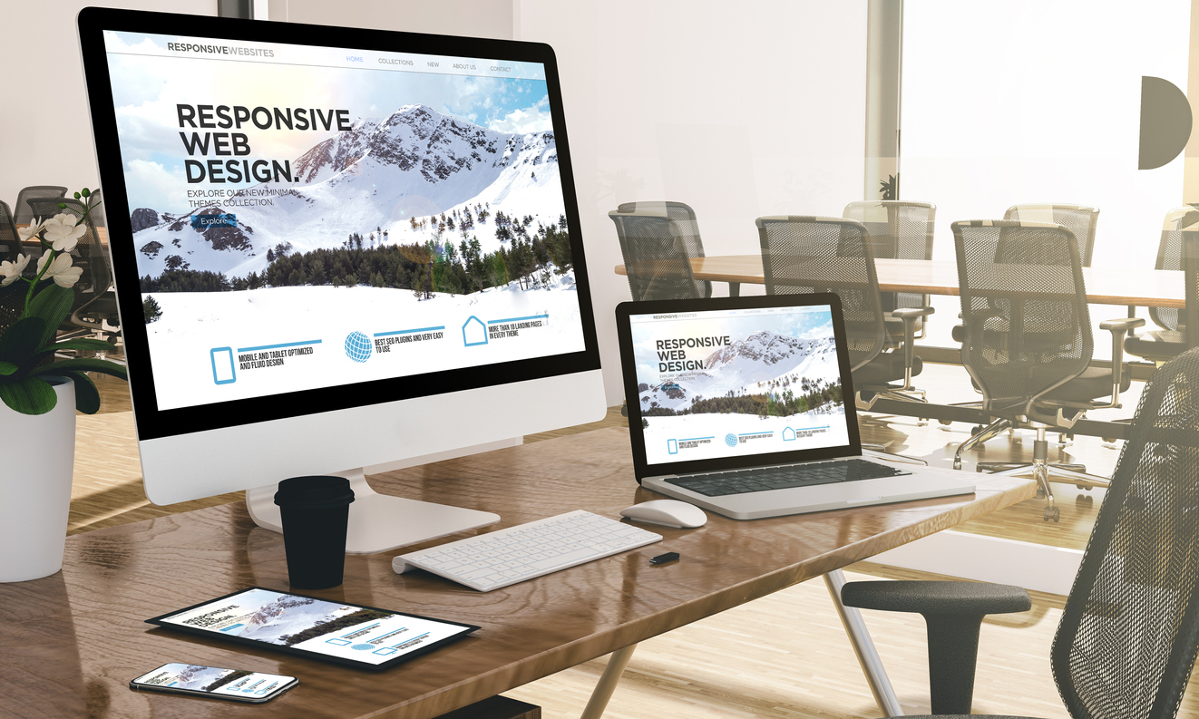 Computer, laptop, tablet, and phone with responsive web design website at office mockup SEO Strategy