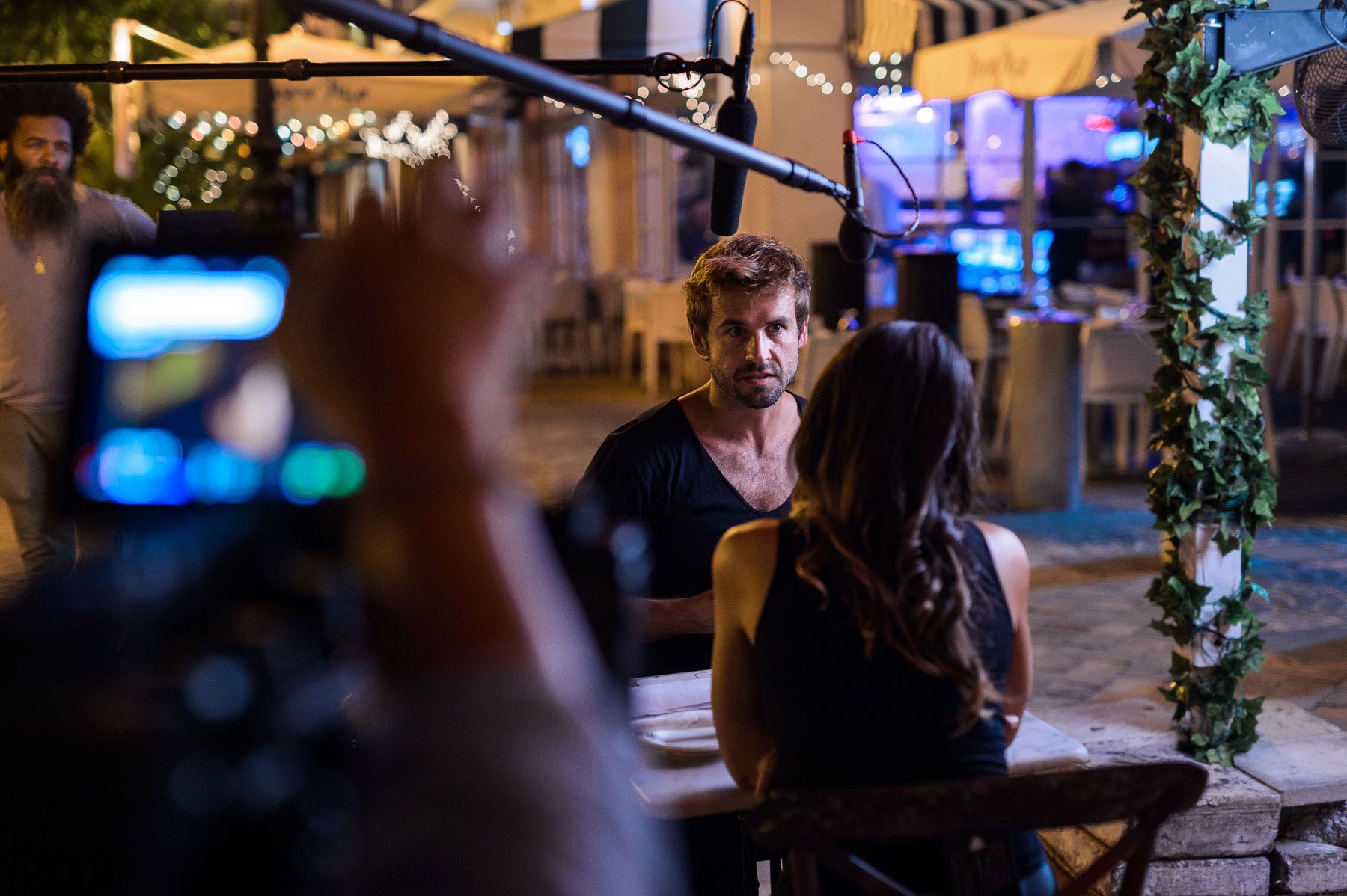 Love and War Feature film mastering and delivery services by C&I Studios Crew member filming a man and woman sitting at a table in a restaurant
