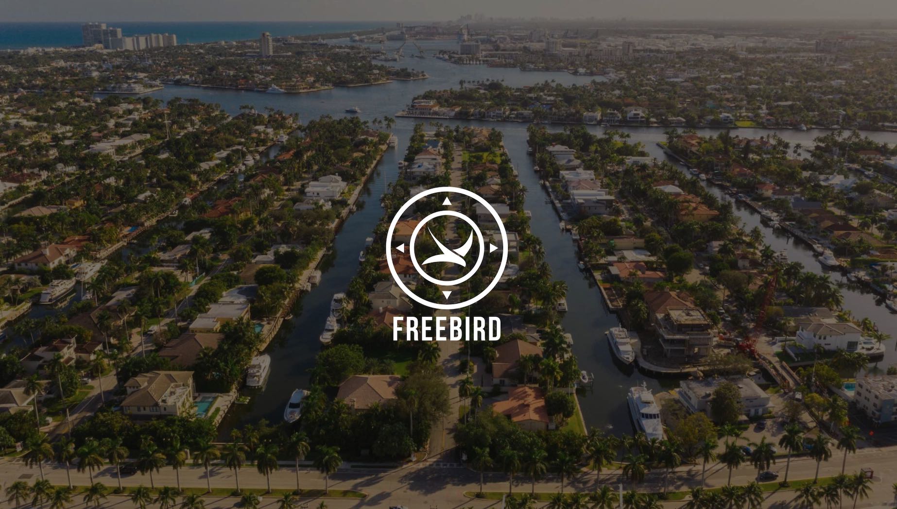 IU C&I Studios Page White Freebird logo website development on dimmed background aerial view of houses with canals with boats anchored