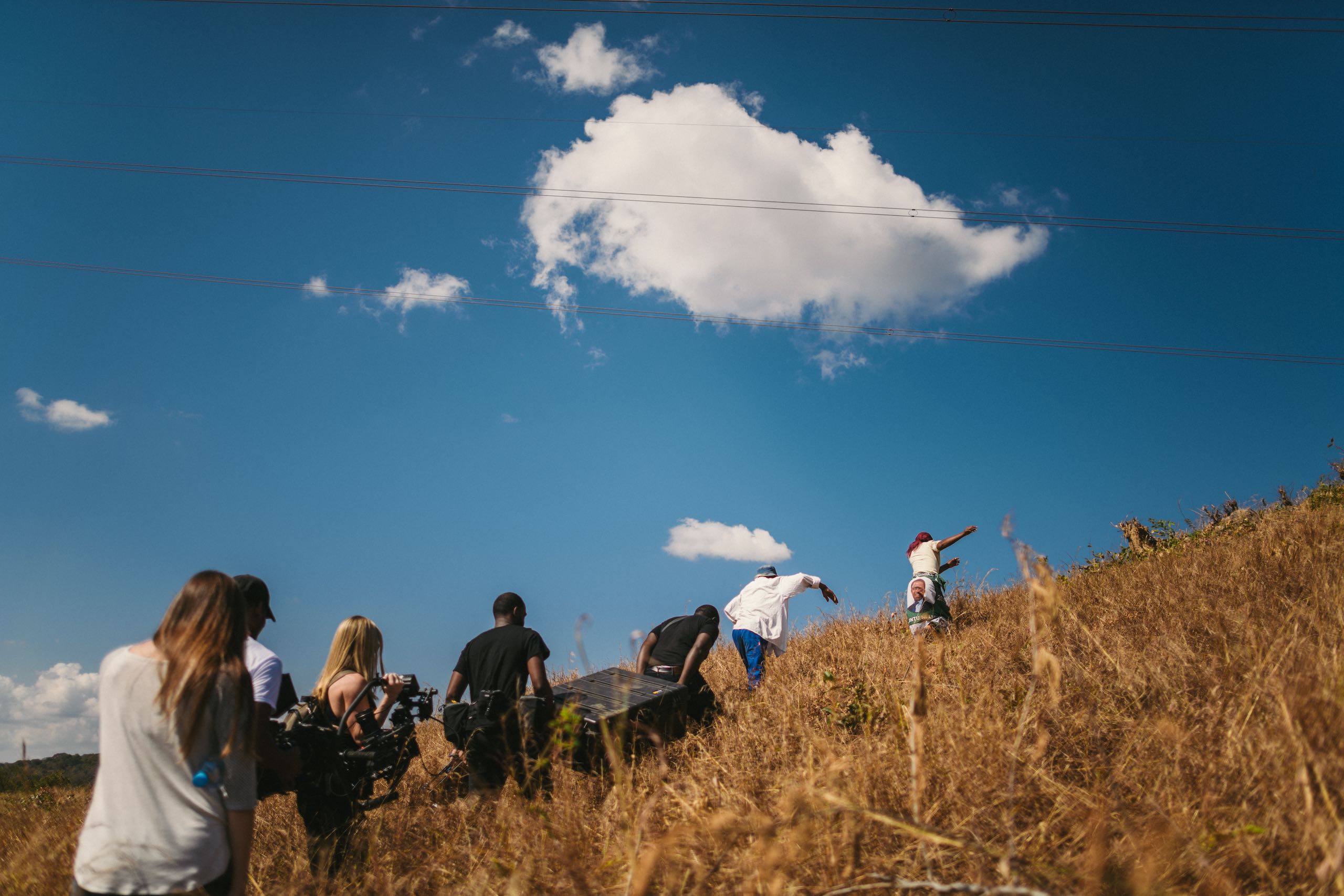 Video Production Abroad with crew members climbing a hill carrying equipment