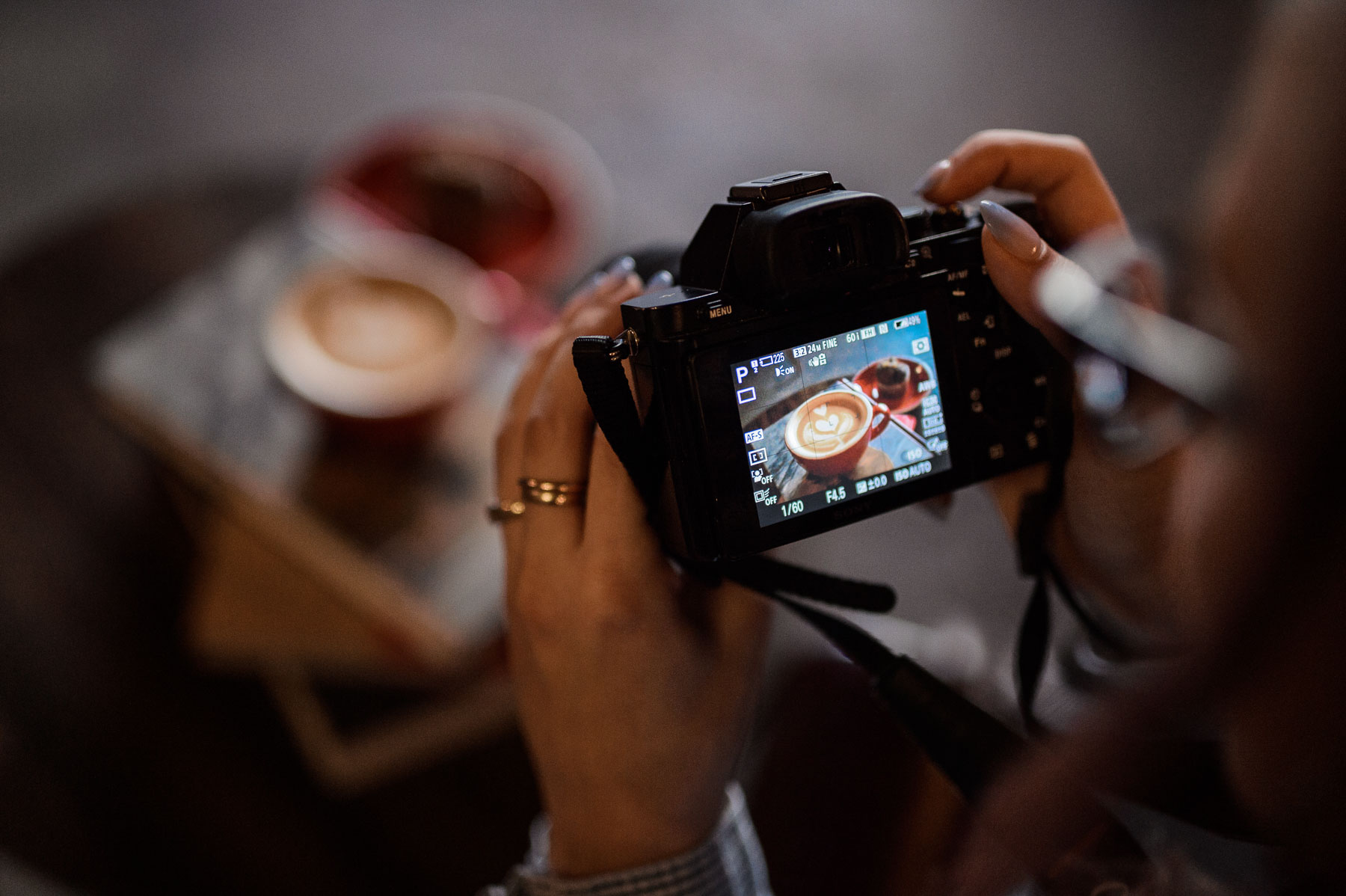 Closeup of camera being used on a cup of cappuccino