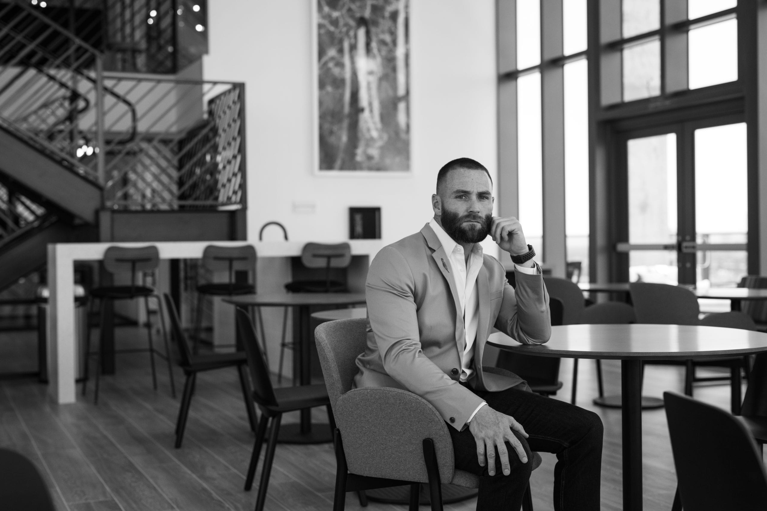 Fort Lauderdale Illustrated Men of Style Black and white of male model with beard in a suit sitting in a chair at a table