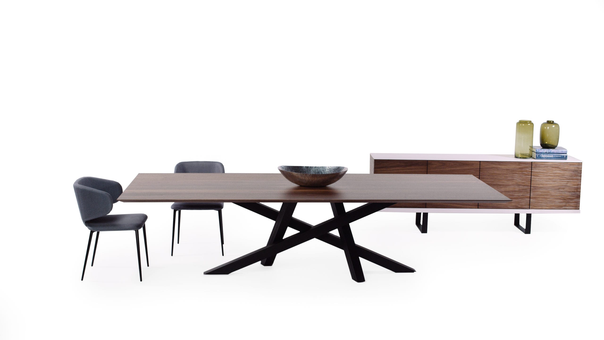 Yiannis Proofs Wooden table with black legs on display with gray chairs and wooden cabinet