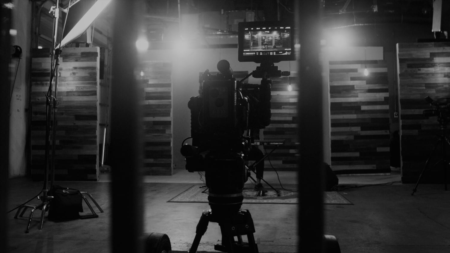 Black and white photo of lighting and video camera equipment on the set