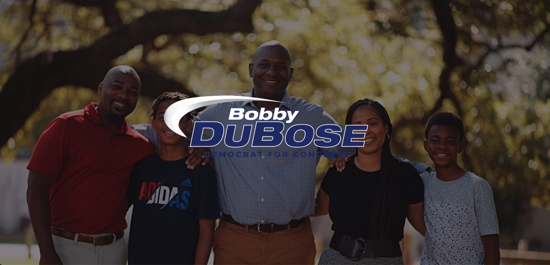 IU C&I Studios Page Bobby Dubose Cover with blue and white logo with backdrop of him posing with two young boys, man and woman for the camera with all of them smiling