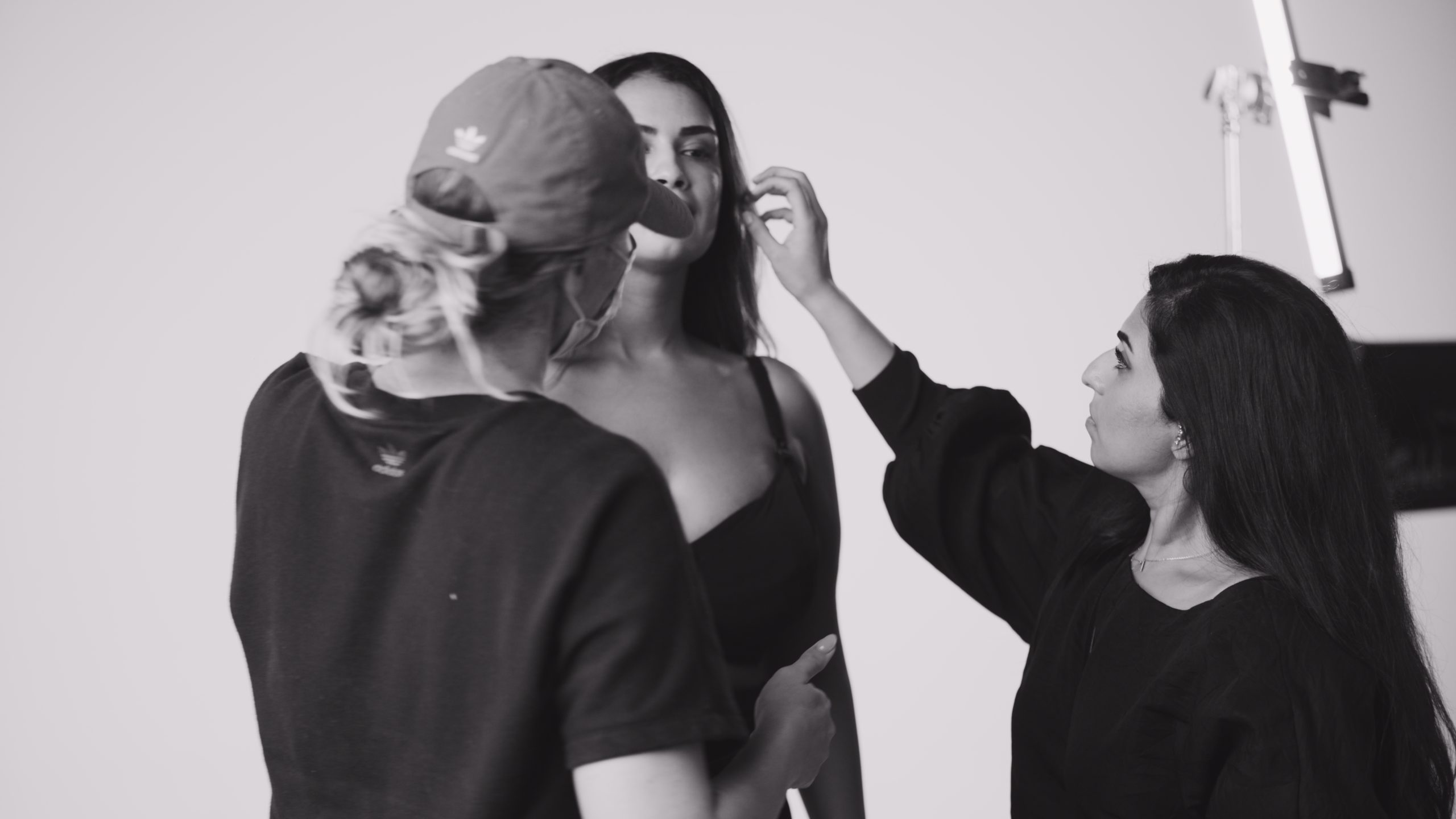 JennaBra Black and white of two women helping with makeup on model wearing bra