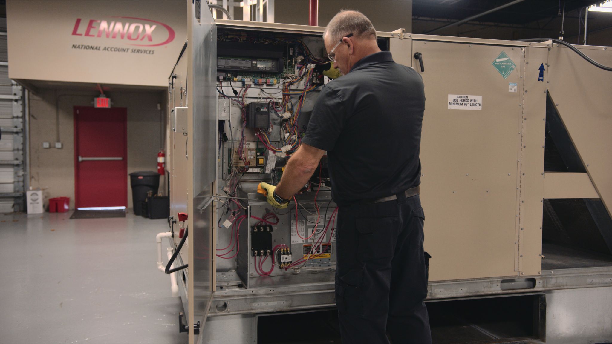 View from behind of man working on electronics in a container