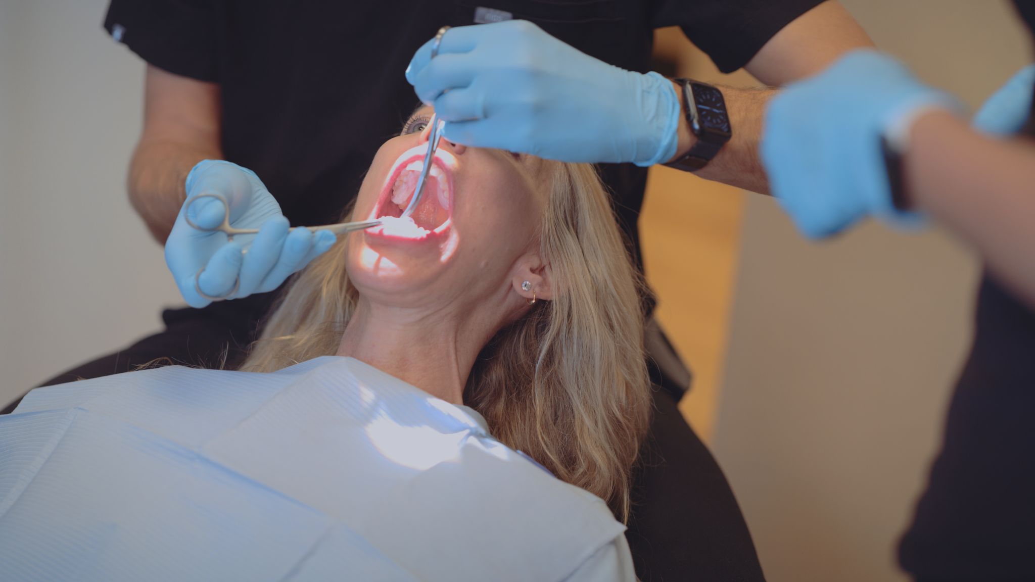 Overhead view of male dentist working on a female patient