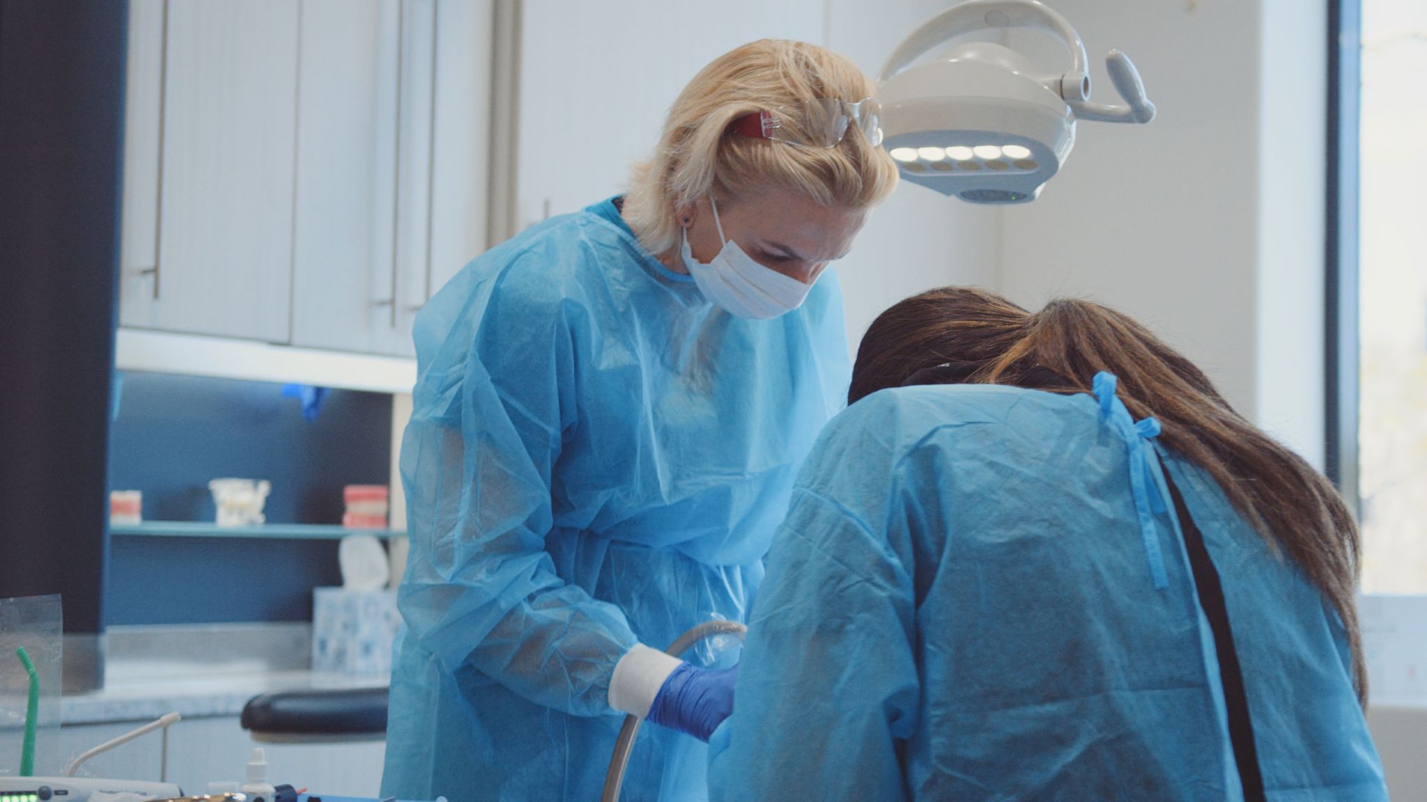 Female dental assistants working on patient