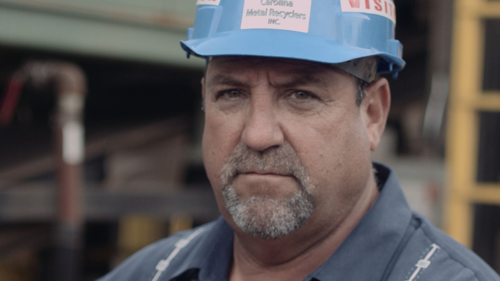 A Fine Solution Headshot of an older worker with goatee wearing a blue hard hat