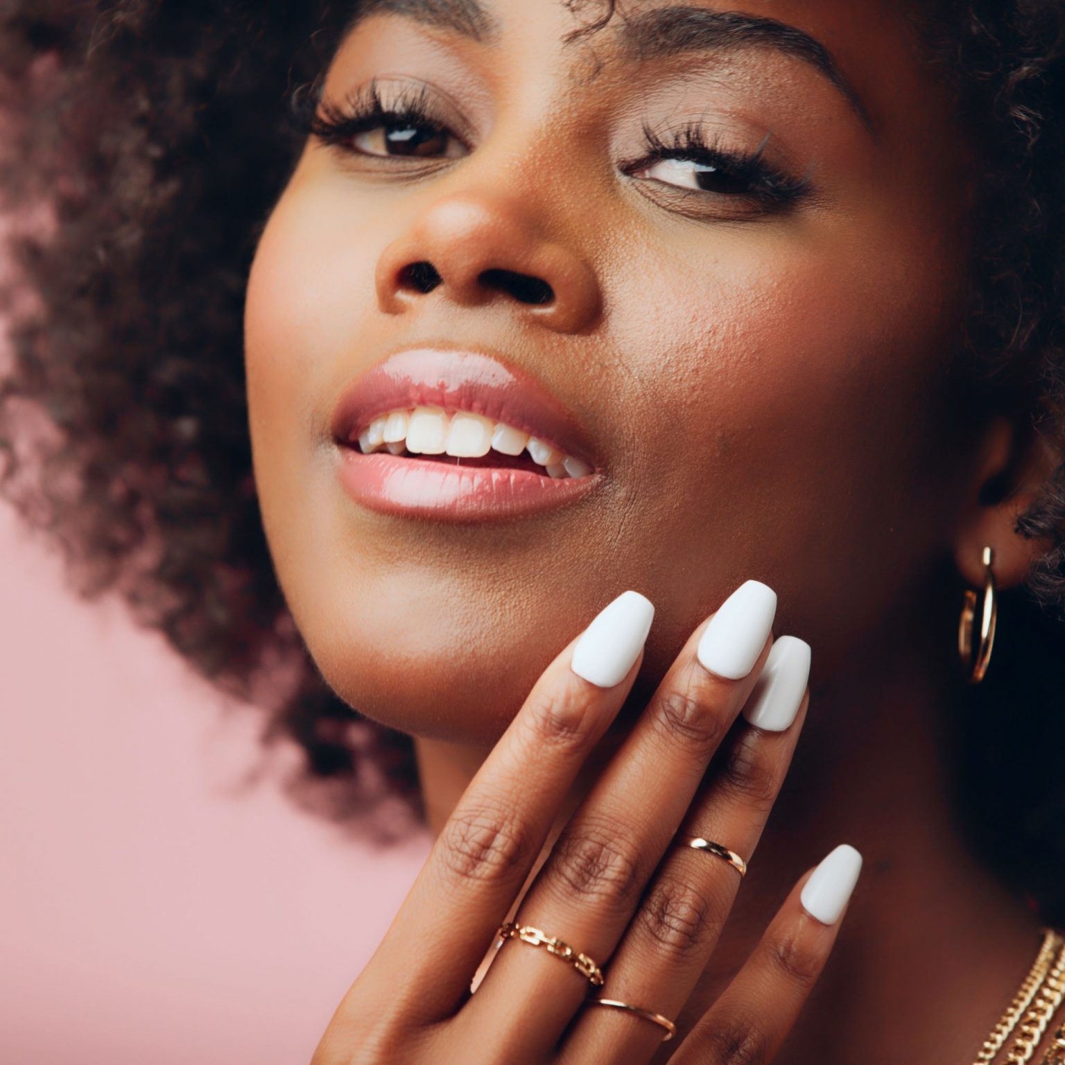 Headshot Of African American Woman Posing For The Camera Showing Off Her White Polished Nails