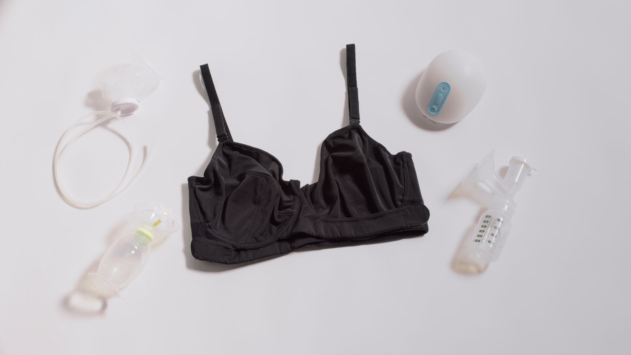 JENNAbra Product Flatlays Black bra on display with breastfeeding devices