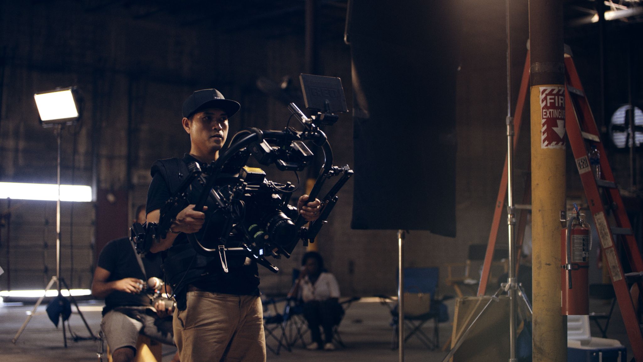 Crew member using a video camera on a set