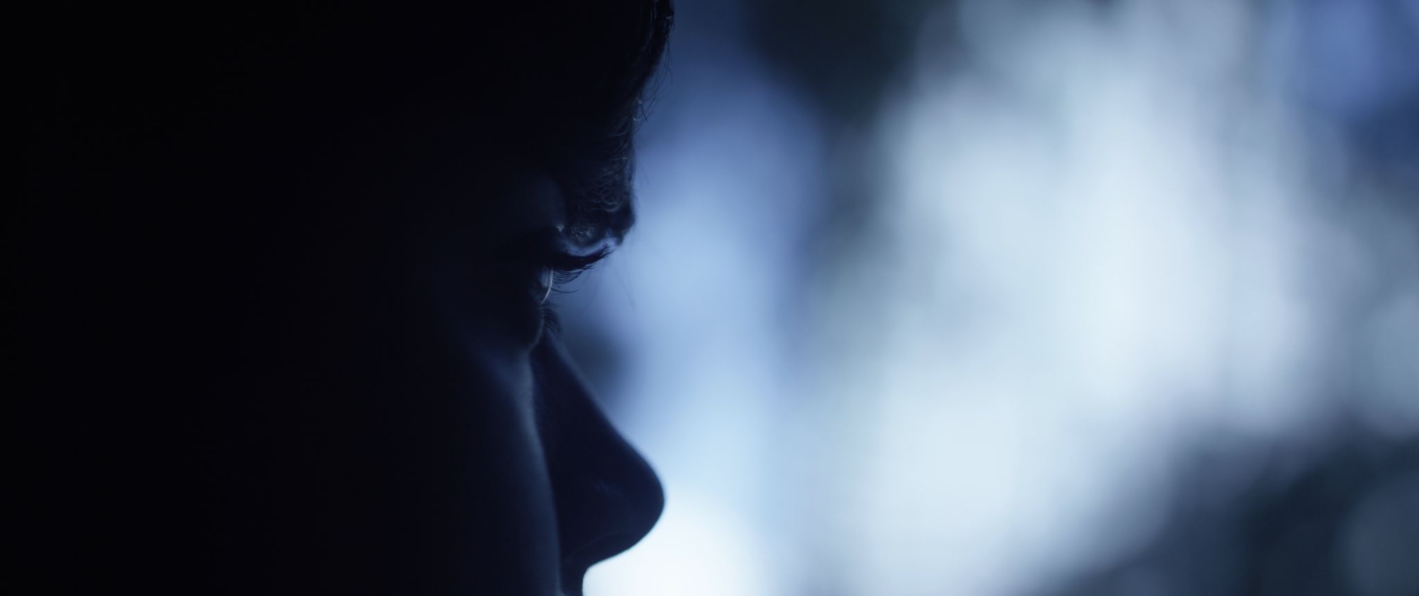 Side profile of person in semidarkness