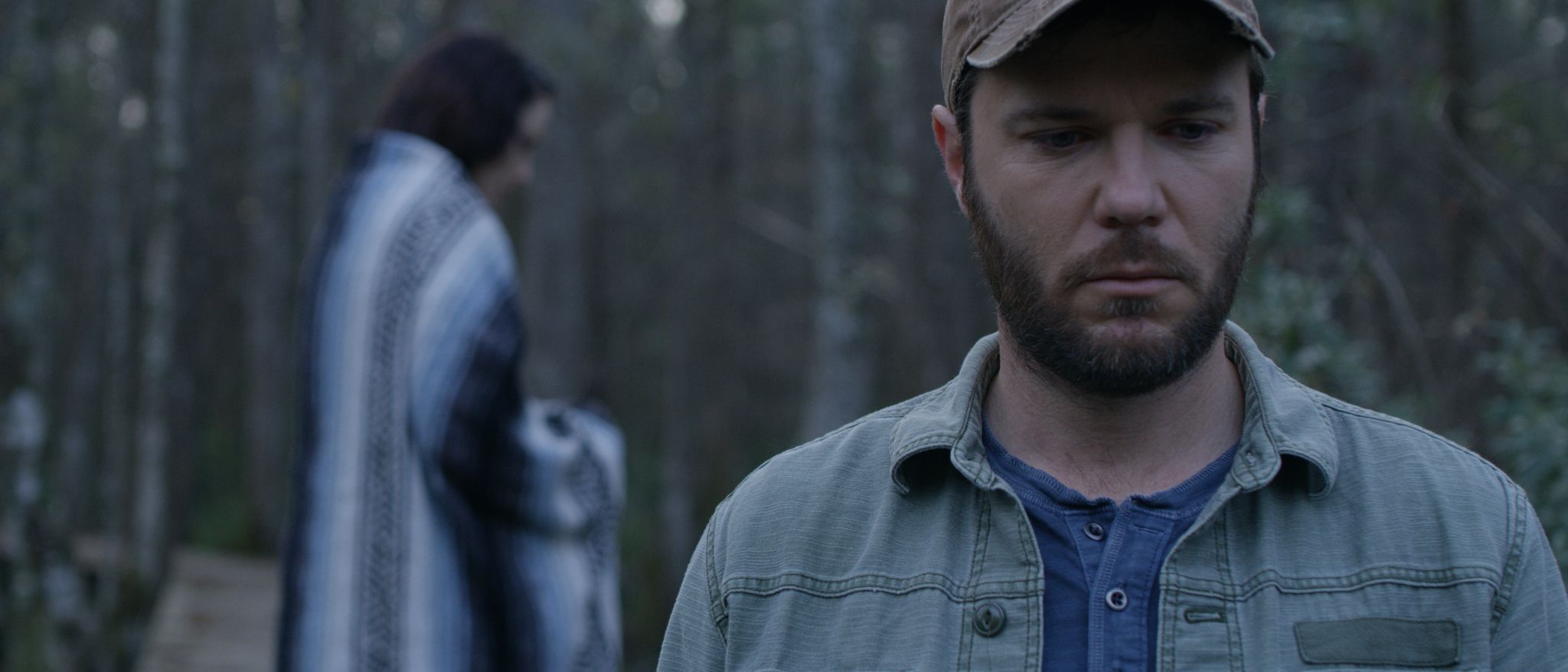 The Elements of an Effective Brand Film Man with beard wearing beige cap looking down while woman stand behind him wearing a blanket