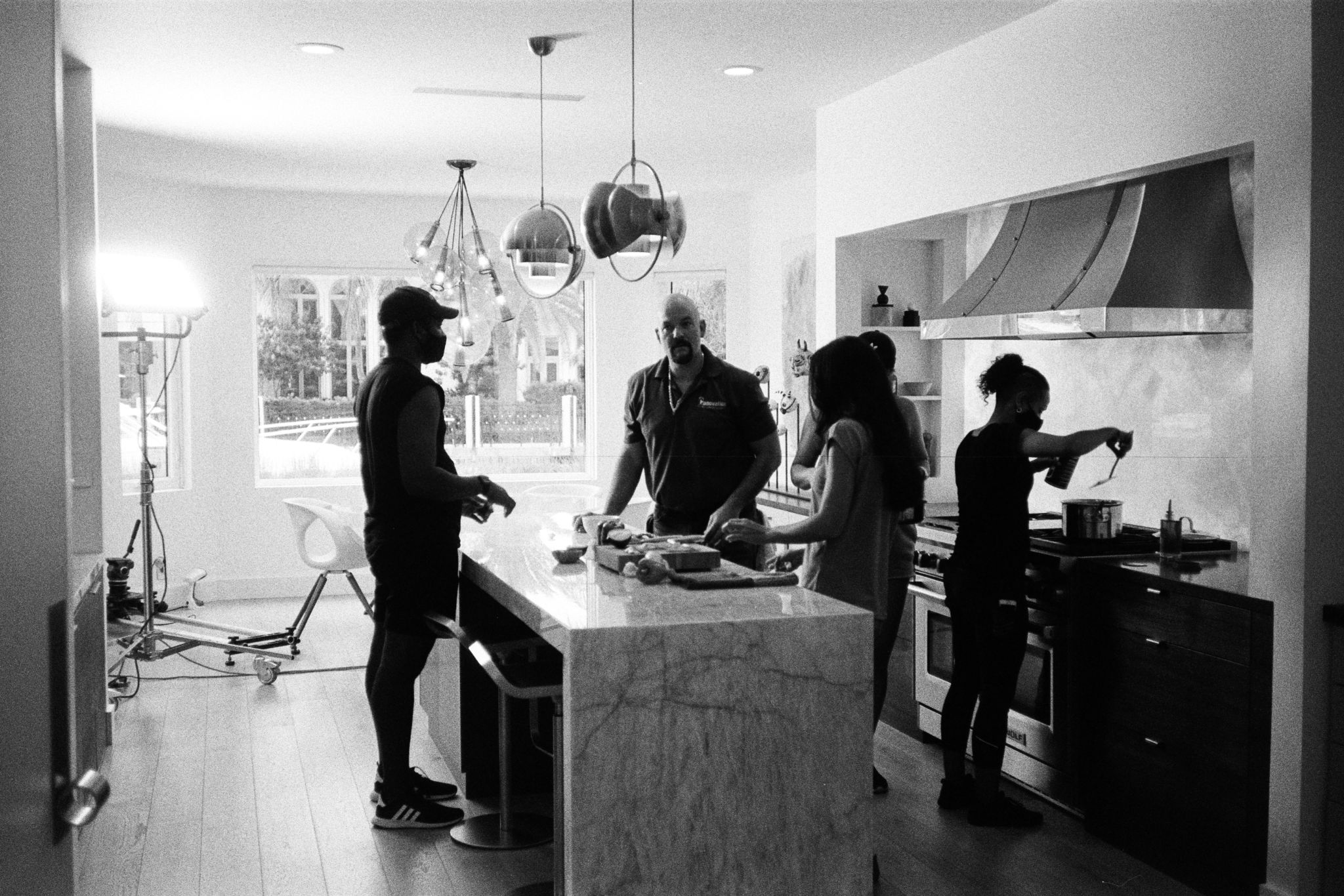 Black and white of crew and actors on a kitchen set
