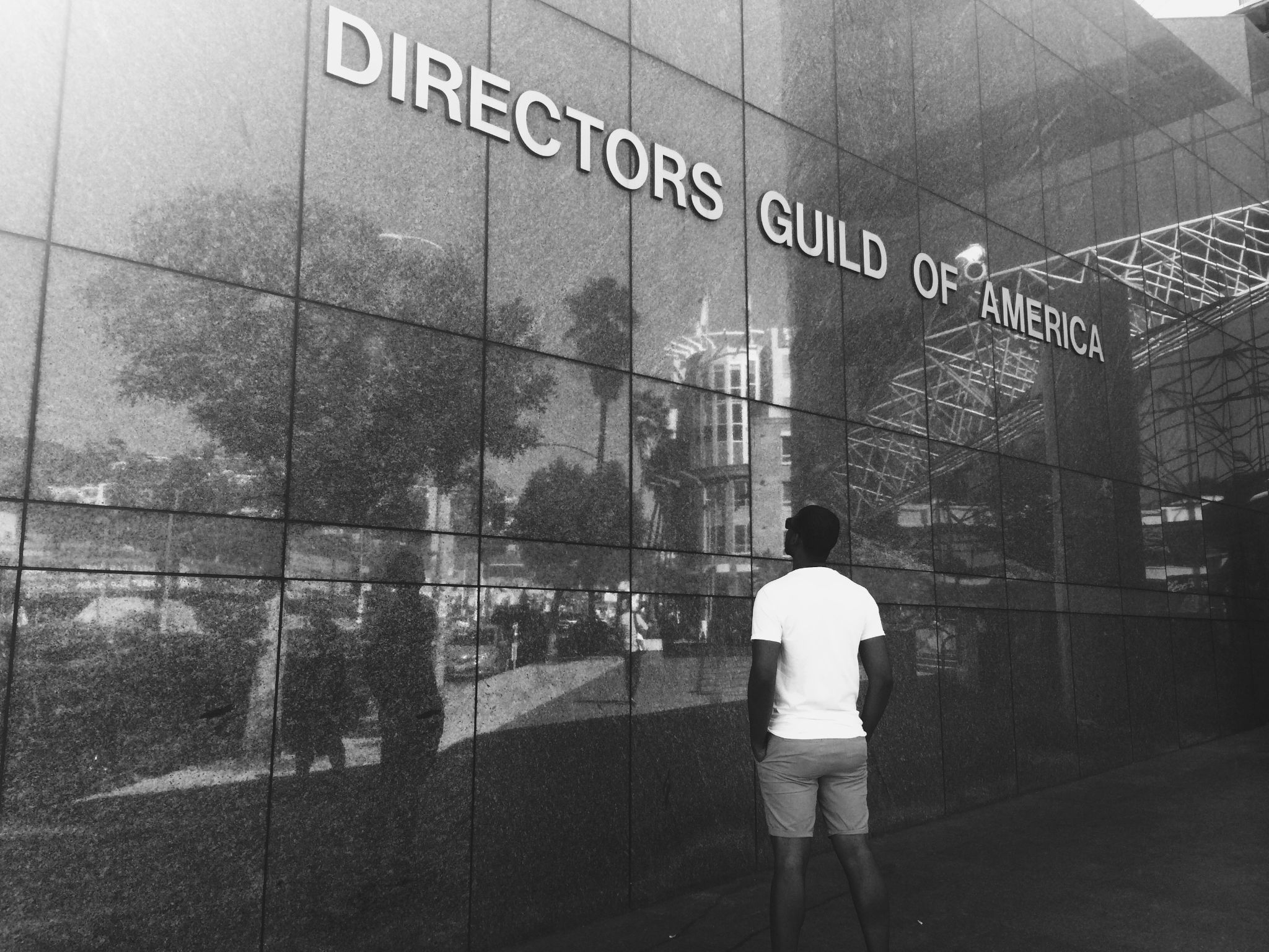 Black and white of Joshua Otis Miller Chief Executive Officer in front of Director's Guild of America building in LA