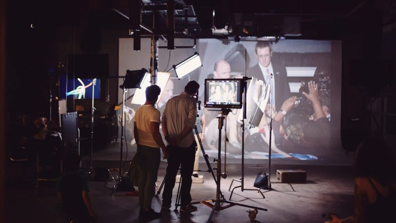 Crew Members Filming Projector Images On A Set
