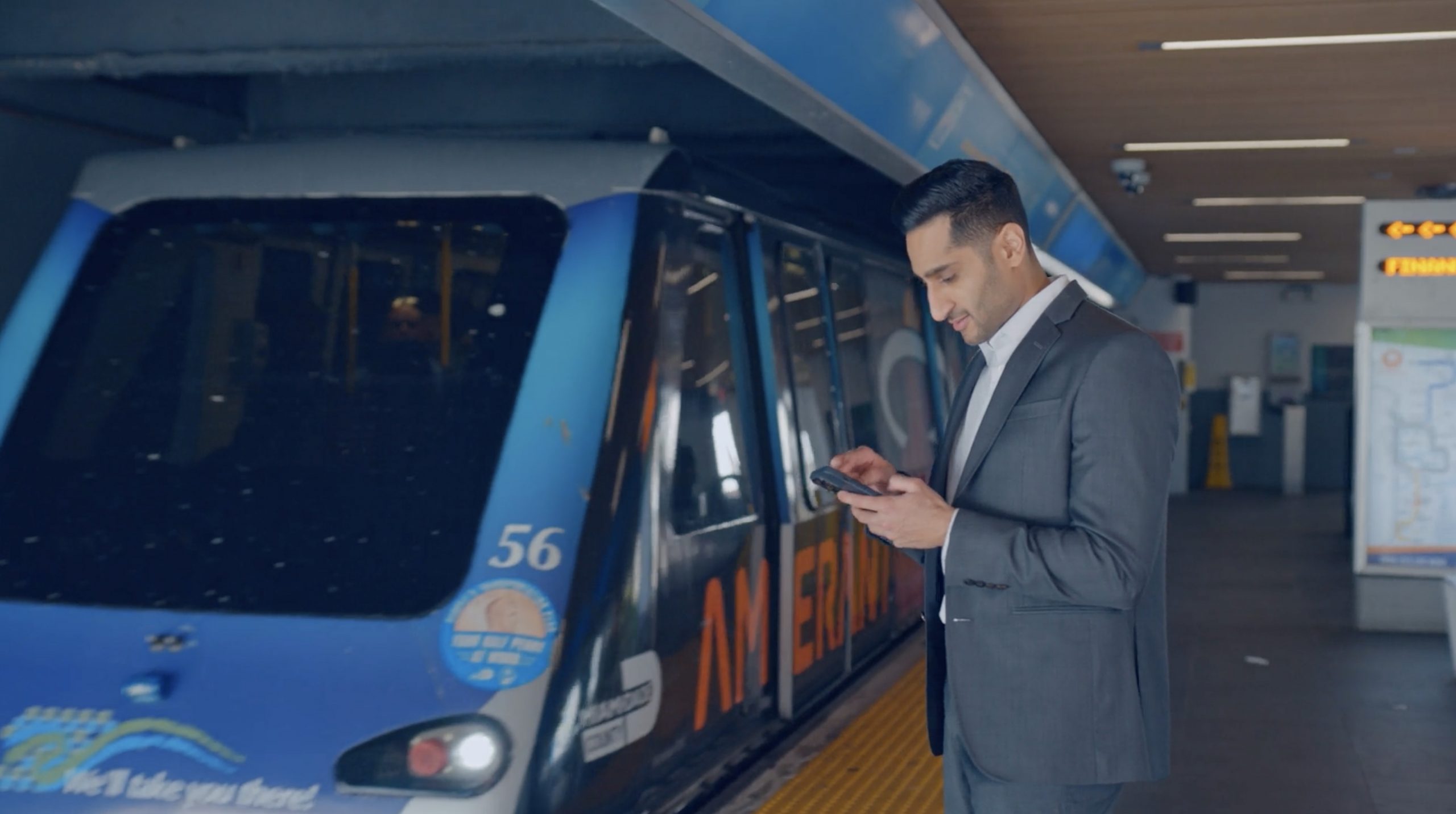 IU Man in Miami waiting for the public transit tram using iPhone with AT&T 5G network
