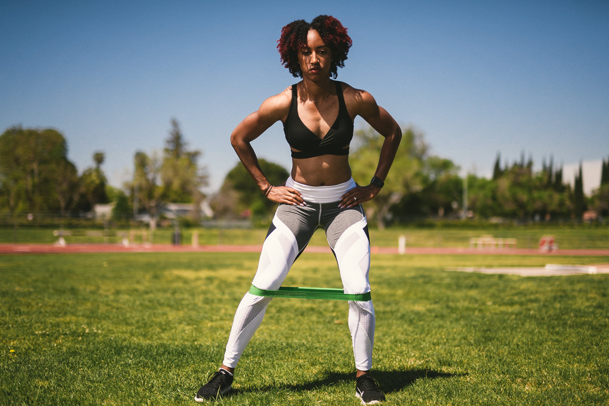 Professional Photography Services to elevate your brand C&I Studios Creative Marketing Kinetix 365 Woman posing for camera on a track field in track outfit using rubber band for stretching