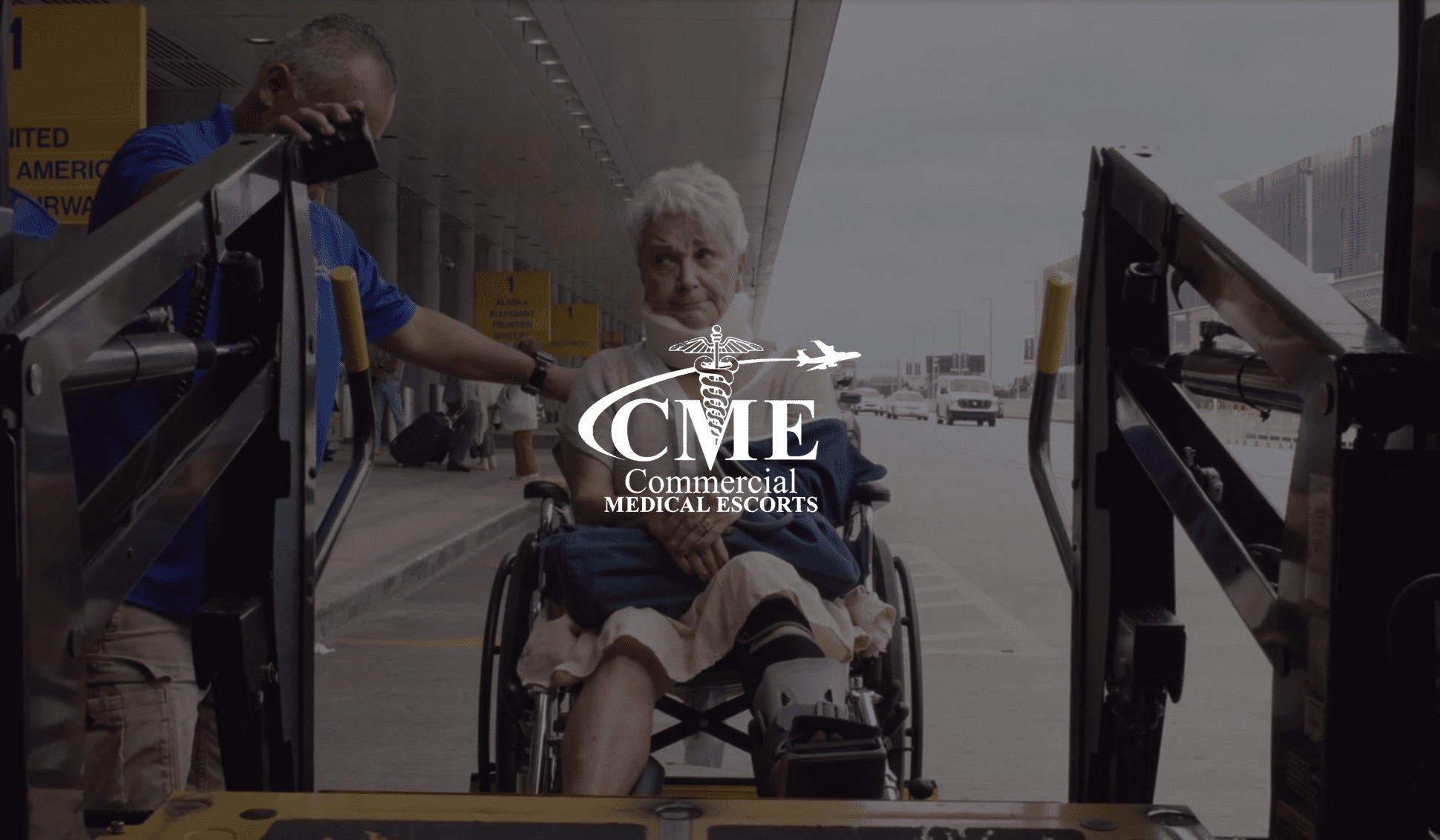 IU C&I Studios Page White Commercial Medical Escorts logo with woman wearing a neck brace in a wheelchair being lifted into a transport vehicle with help of an assistant